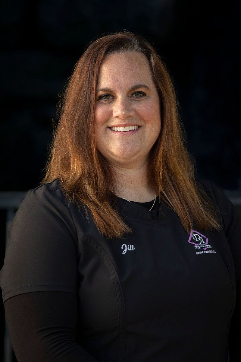 A woman in a black shirt is smiling for the camera.