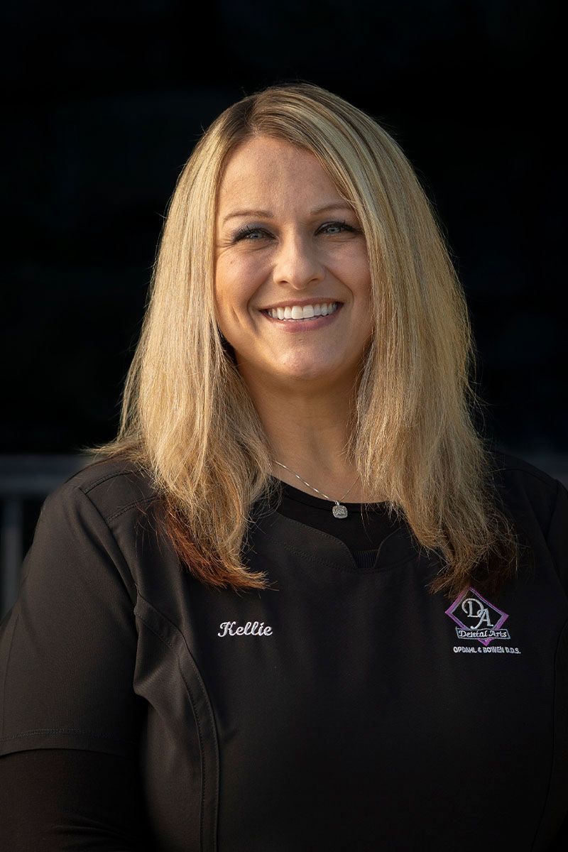A woman in a black shirt is smiling for the camera.