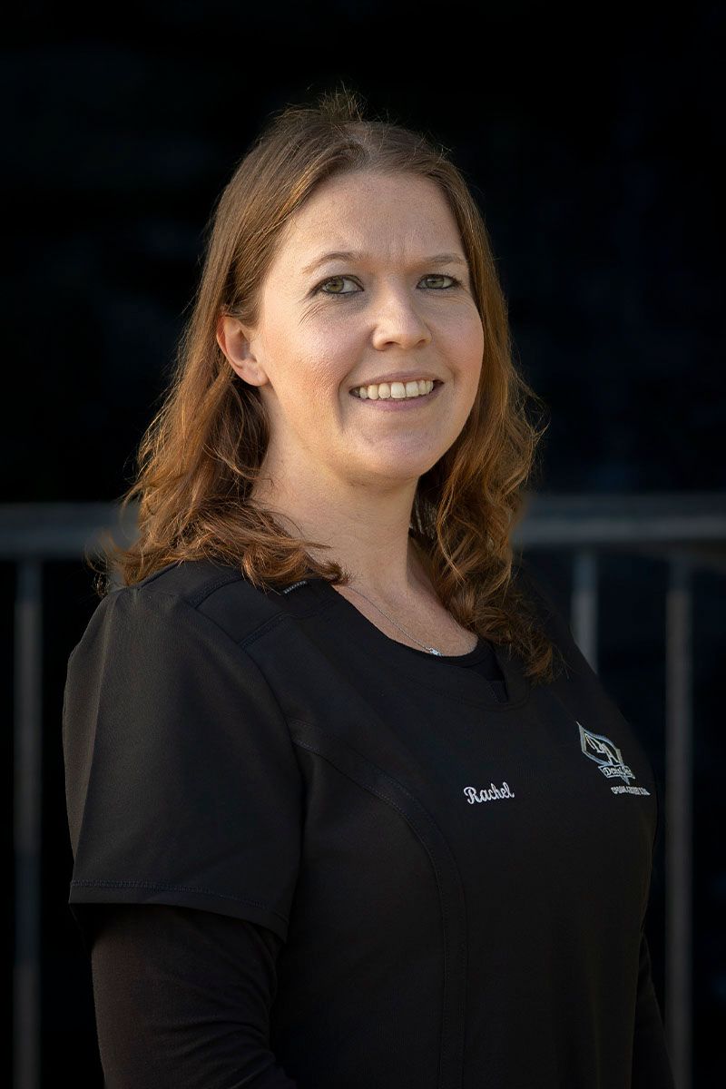 A woman in a black shirt is smiling for the camera.