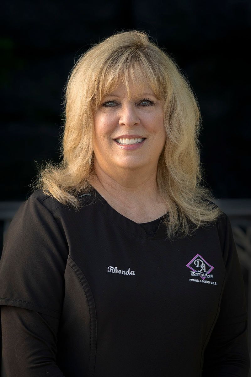 A woman in a black shirt is smiling for the camera.