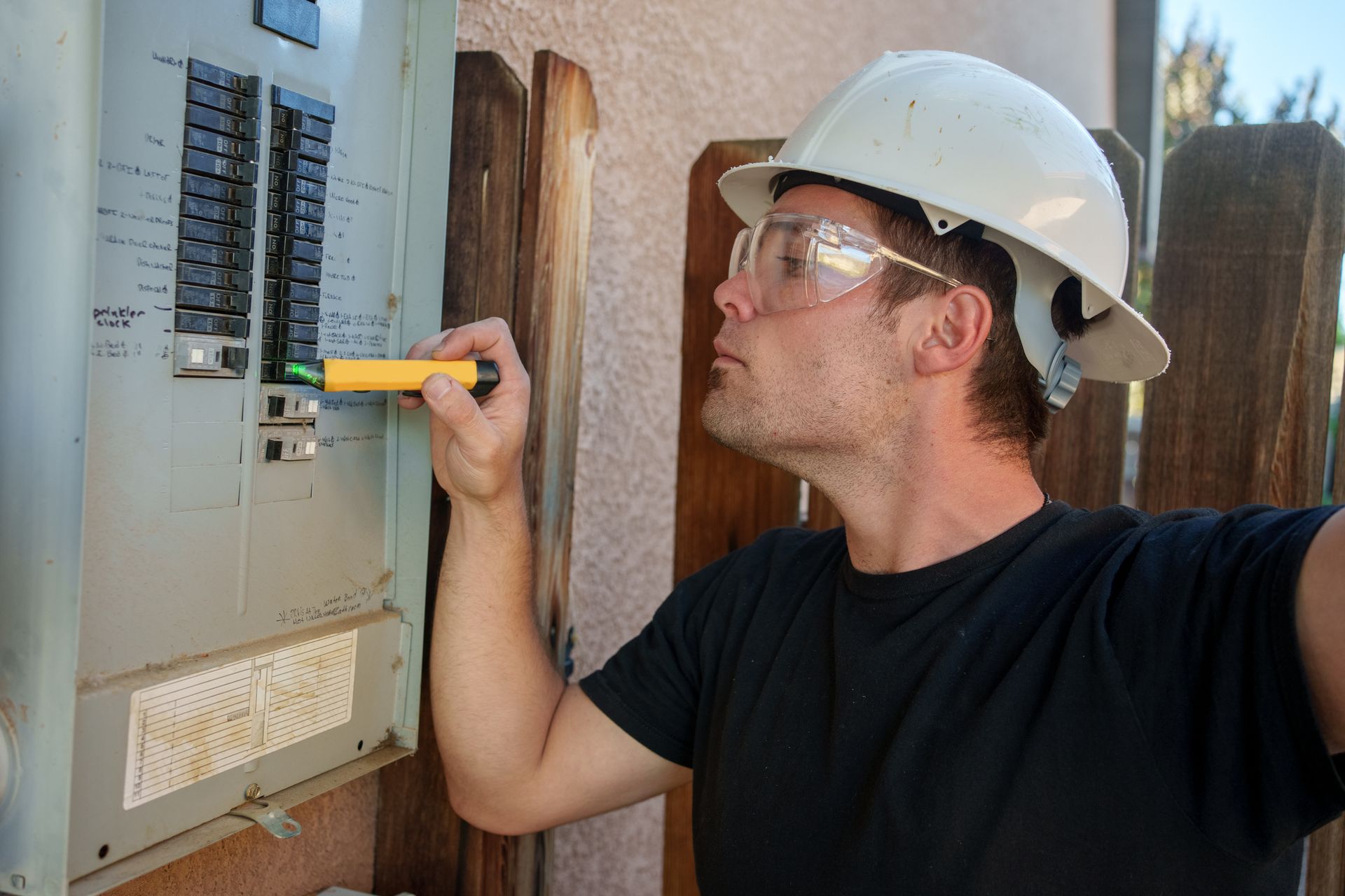 A licensed electrician inspects breaker panels to ensure safety and compliance.