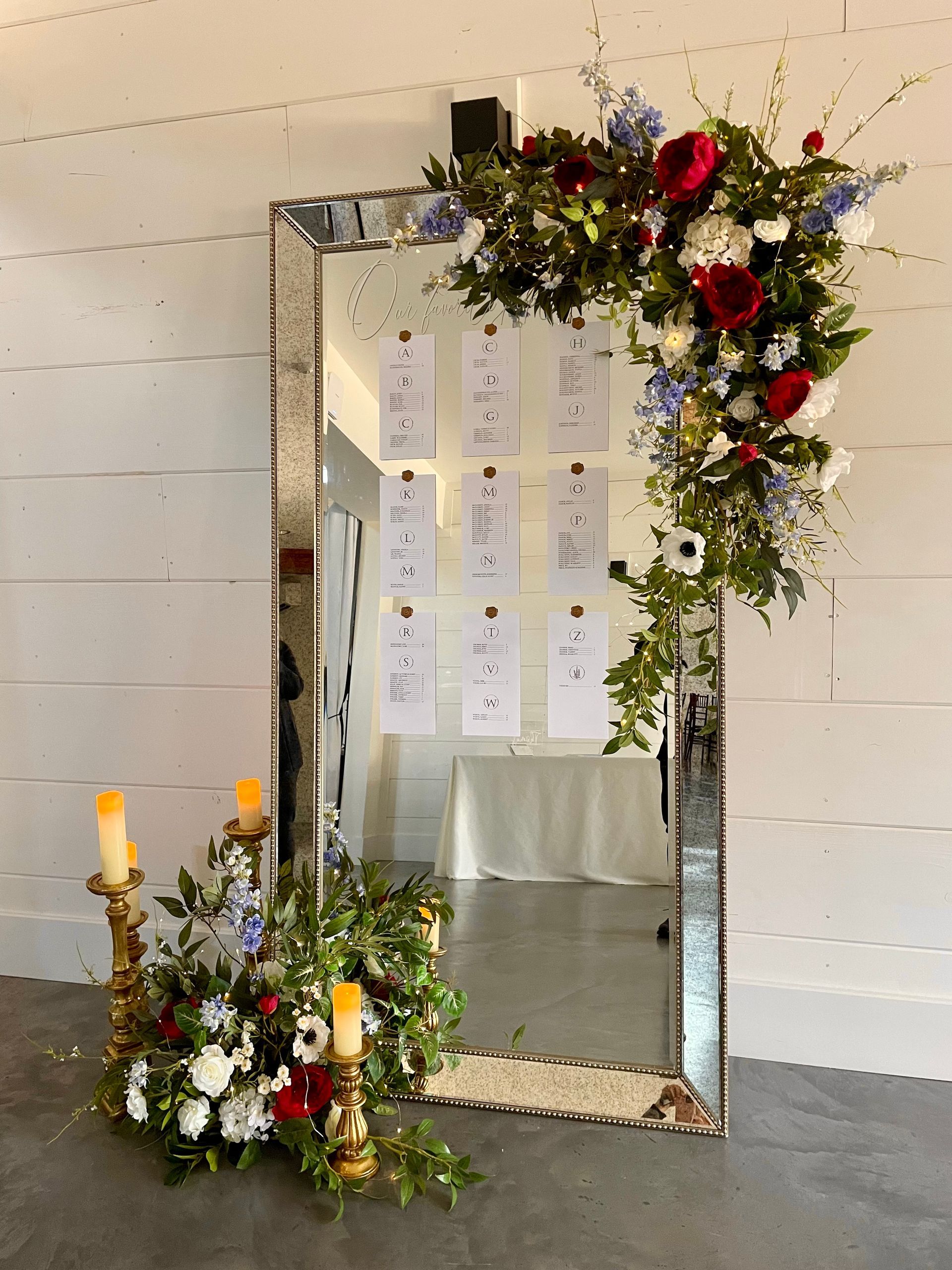 Formal place setting: pink napkin and flowers on white plates, menu, gold accents.
