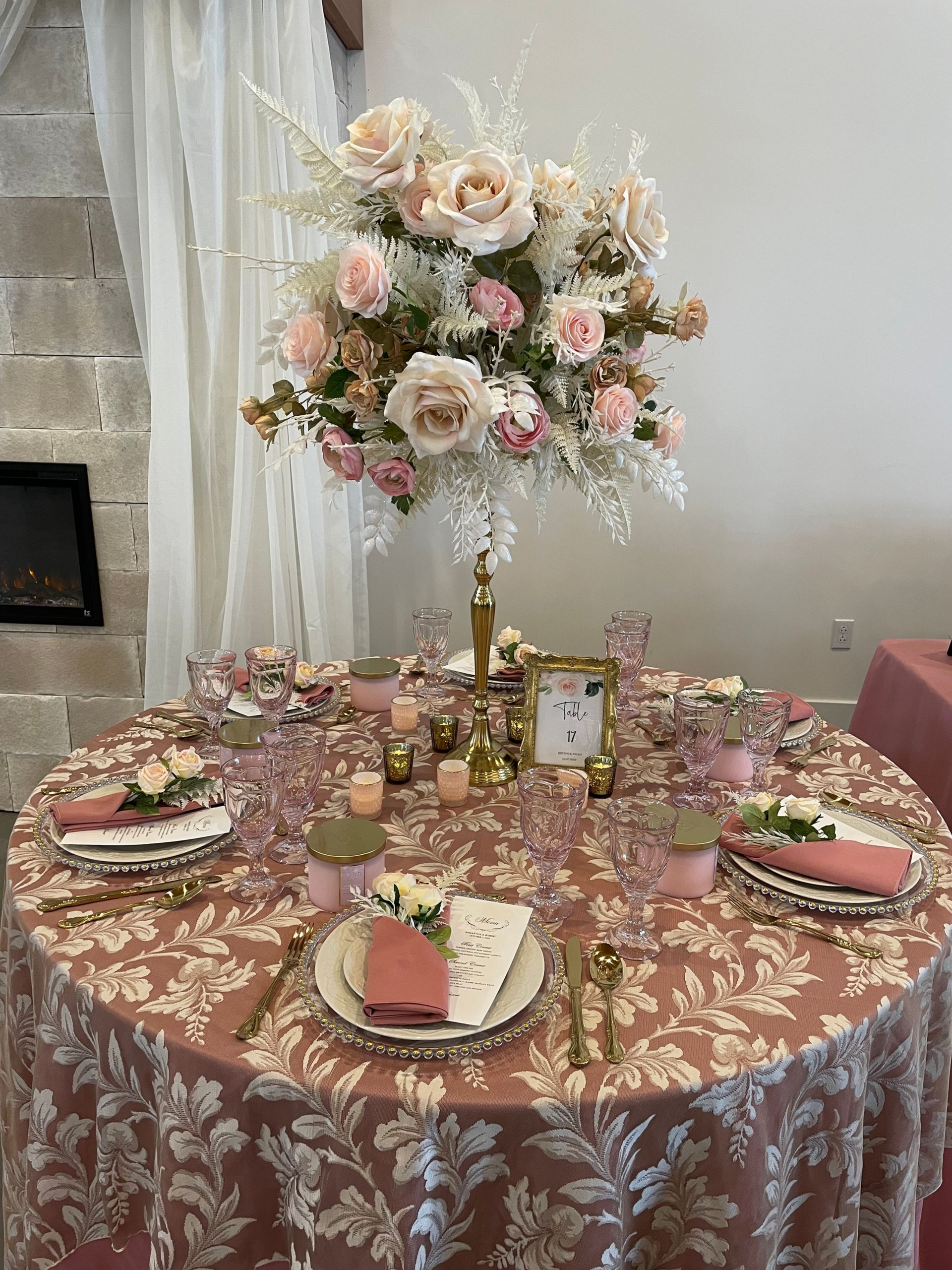 Elegant table setting with pink and gold floral arrangements and decor for a special event.