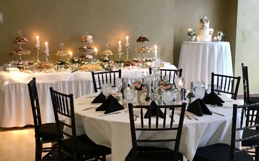 Centerpiece with candles, woodland animal cutouts, and pinecones on a wooden slab, set on a table.