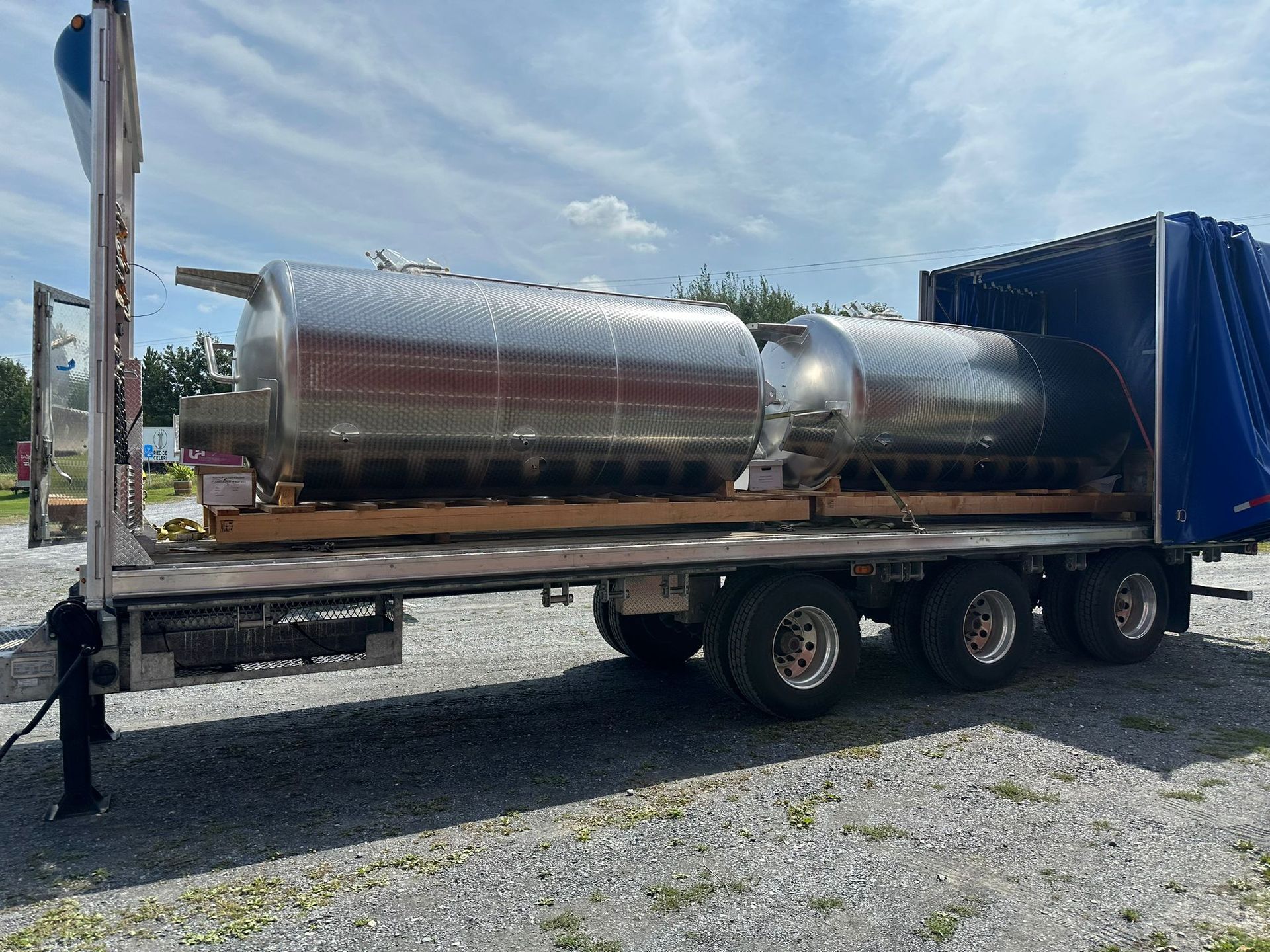Two large, stainless steel tanks on a flatbed trailer, ready for transport.