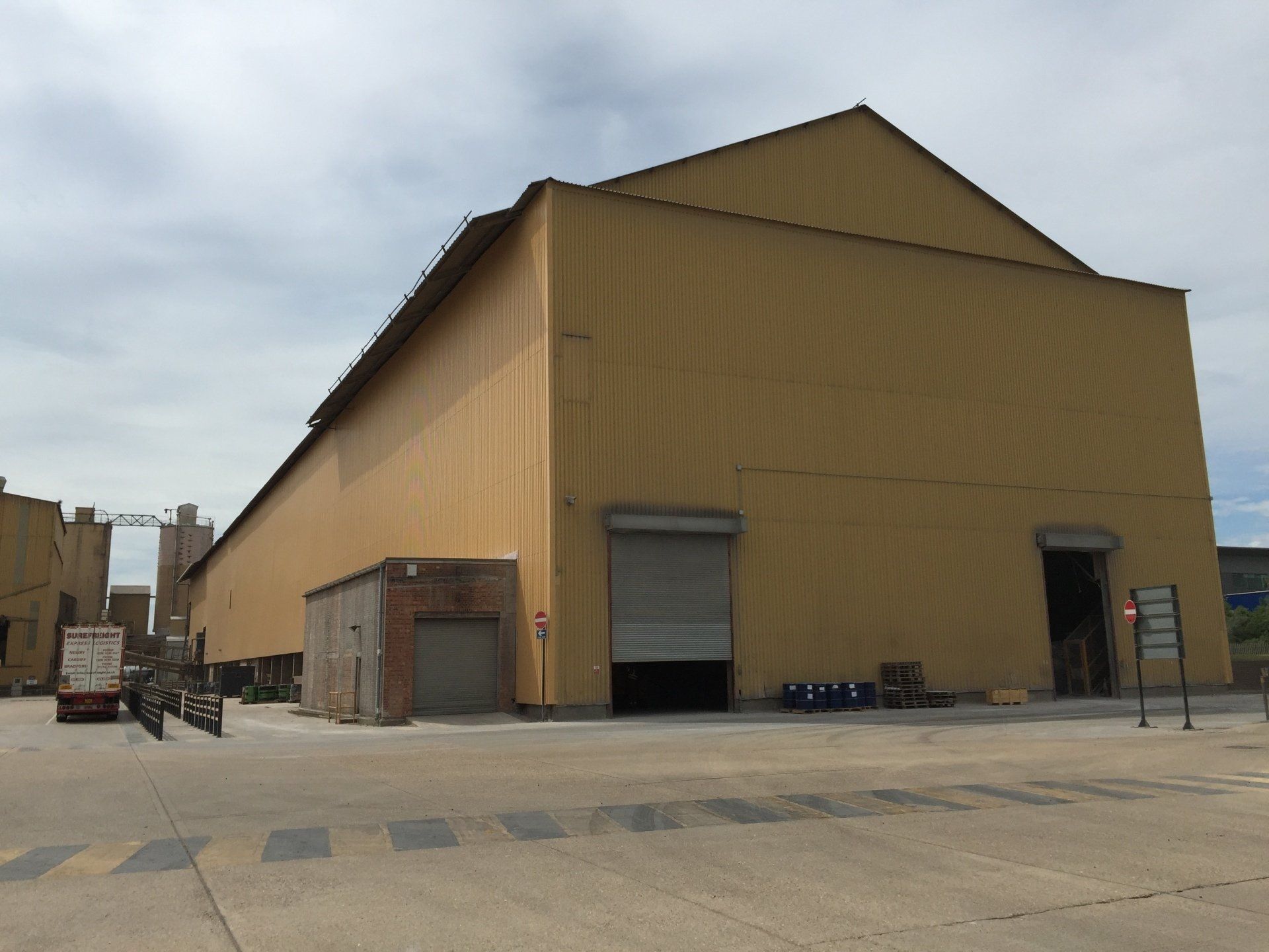 A large yellow building with a white truck parked in front of it