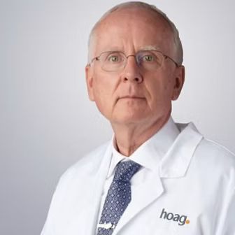 Portrait of a man in a white coat and tie with a Hoag logo against a light background