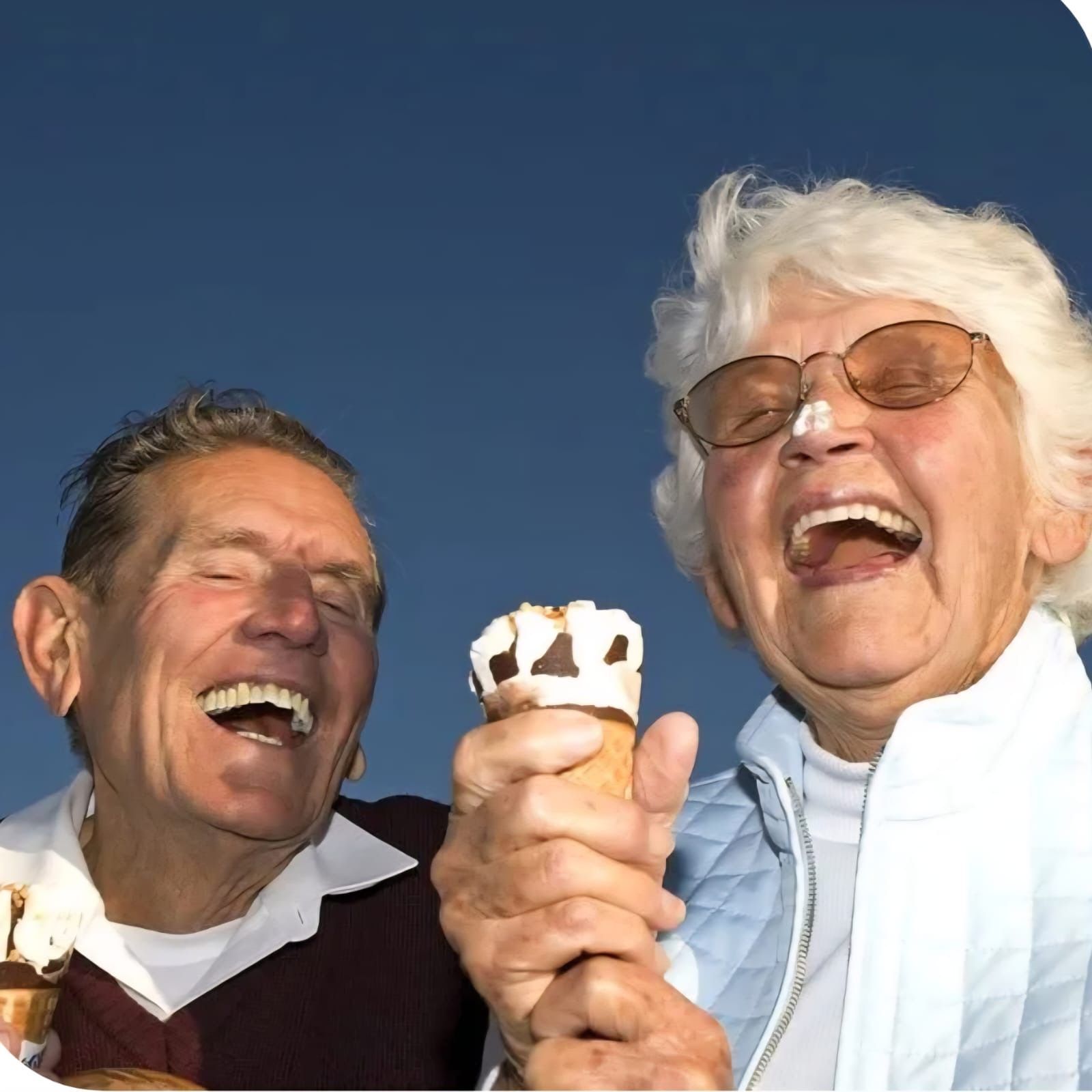 A couple is sharing ice cream with large smiles — Smiles on Hudson In Hamilton, NSW