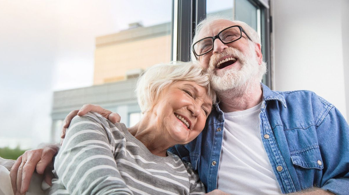 A couple is hugging while sharing large smiles — Smiles on Hudson In Hamilton, NSW
