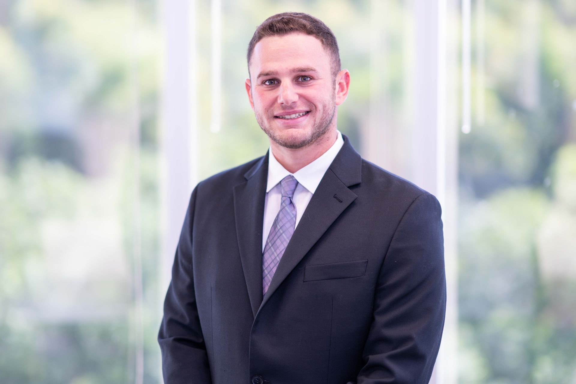 A woman in a suit is sitting at a desk in front of a computer.