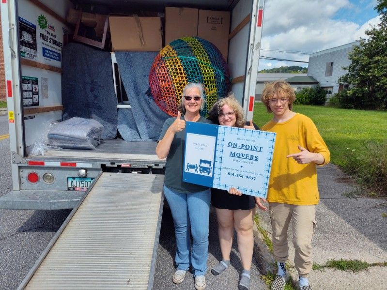 A group of people standing in front of a moving truck