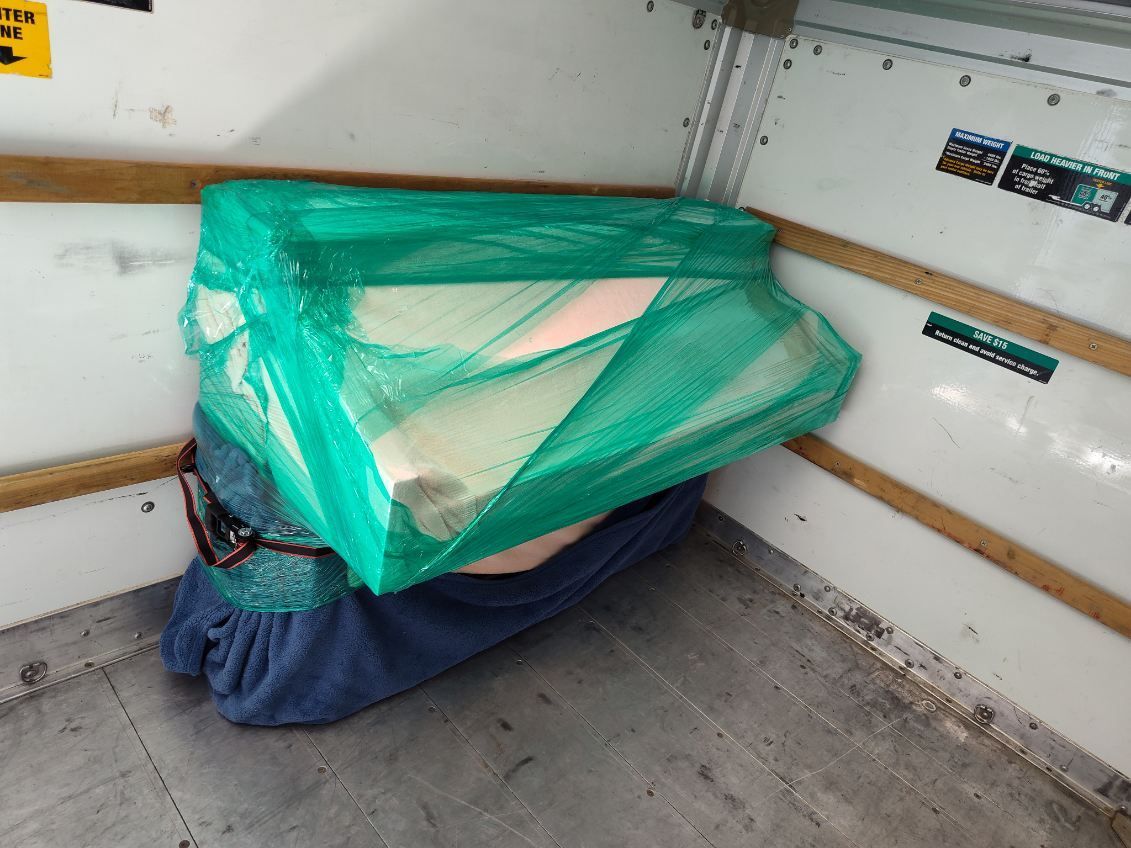 A green bag is sitting on the floor in a room