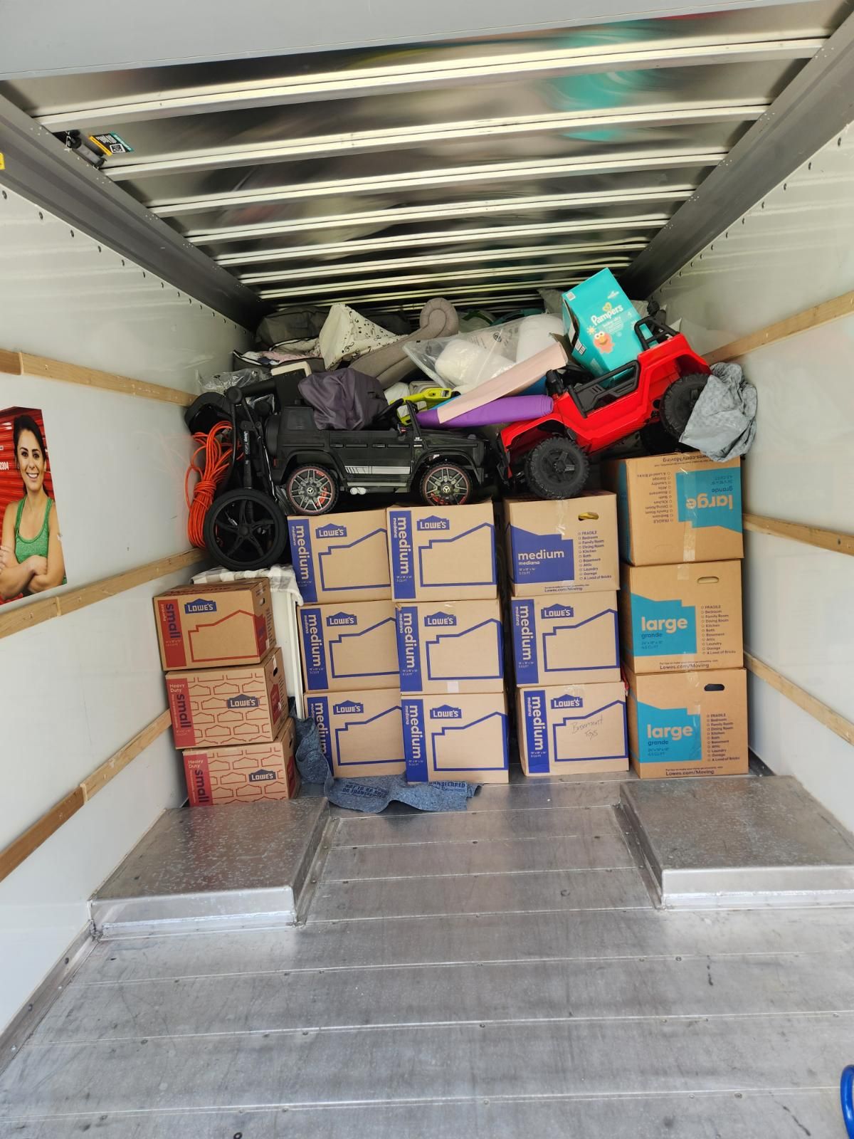 The inside of a moving truck filled with boxes and toys