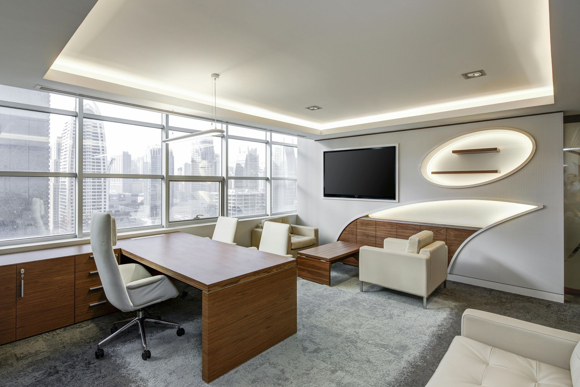 Modern office with city view, desk, seating area, large window, and built-in shelves.