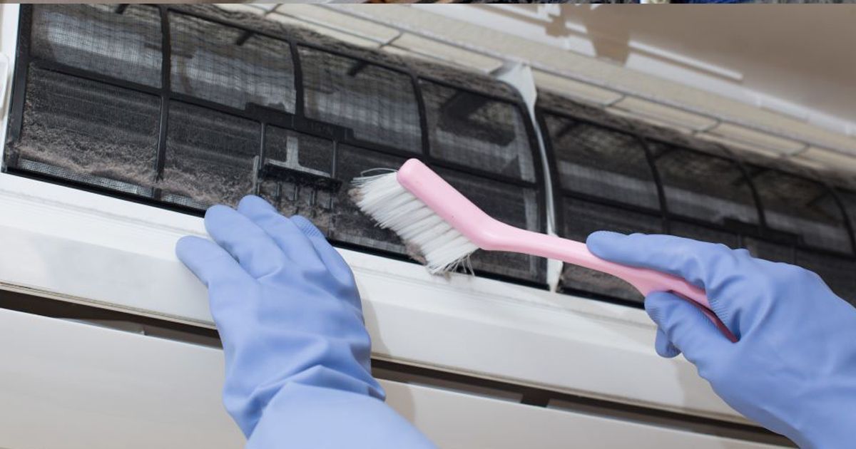 technician cleaning heat pump unit
