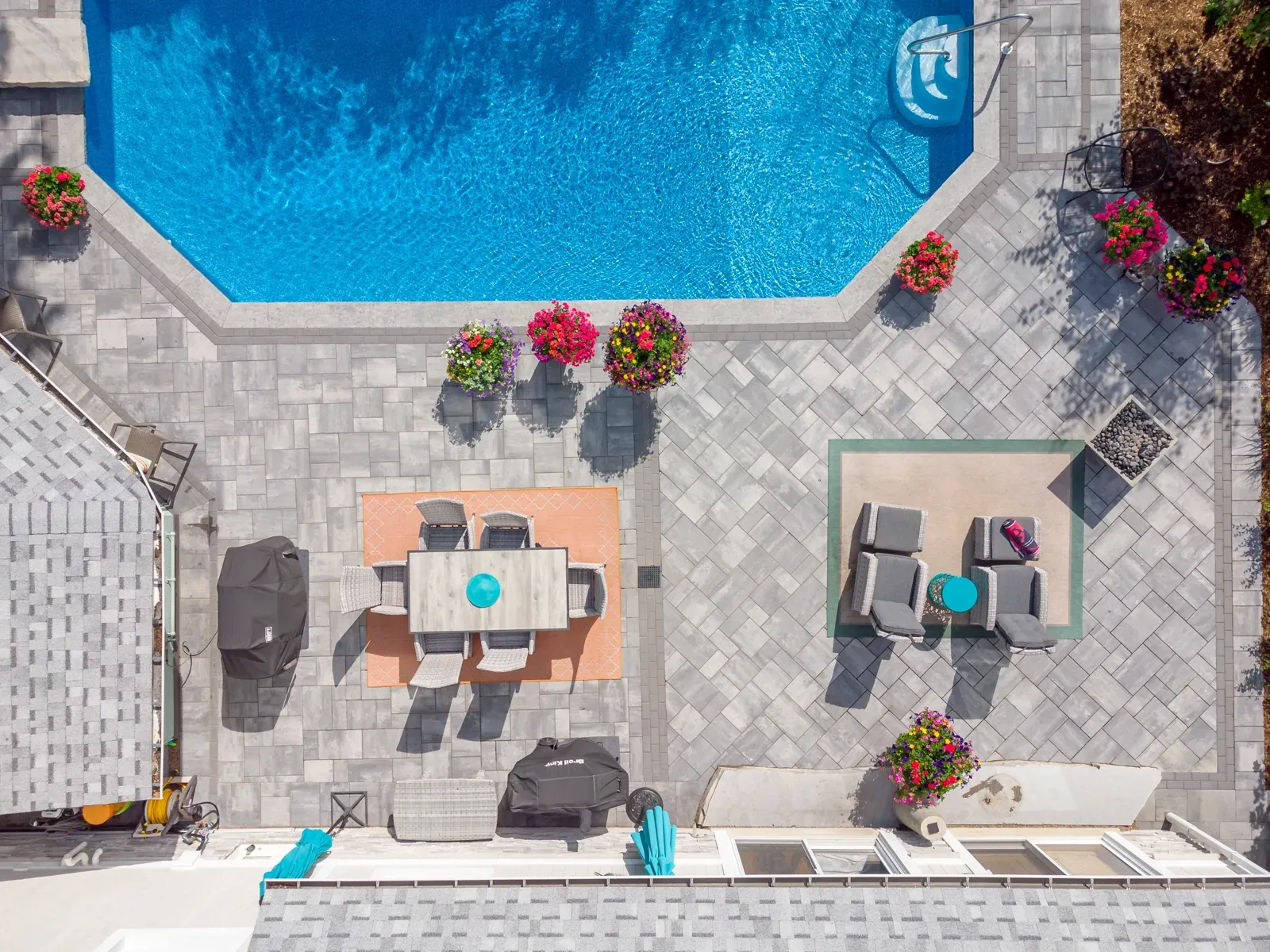 An aerial view of a backyard with a swimming pool and patio furniture.
