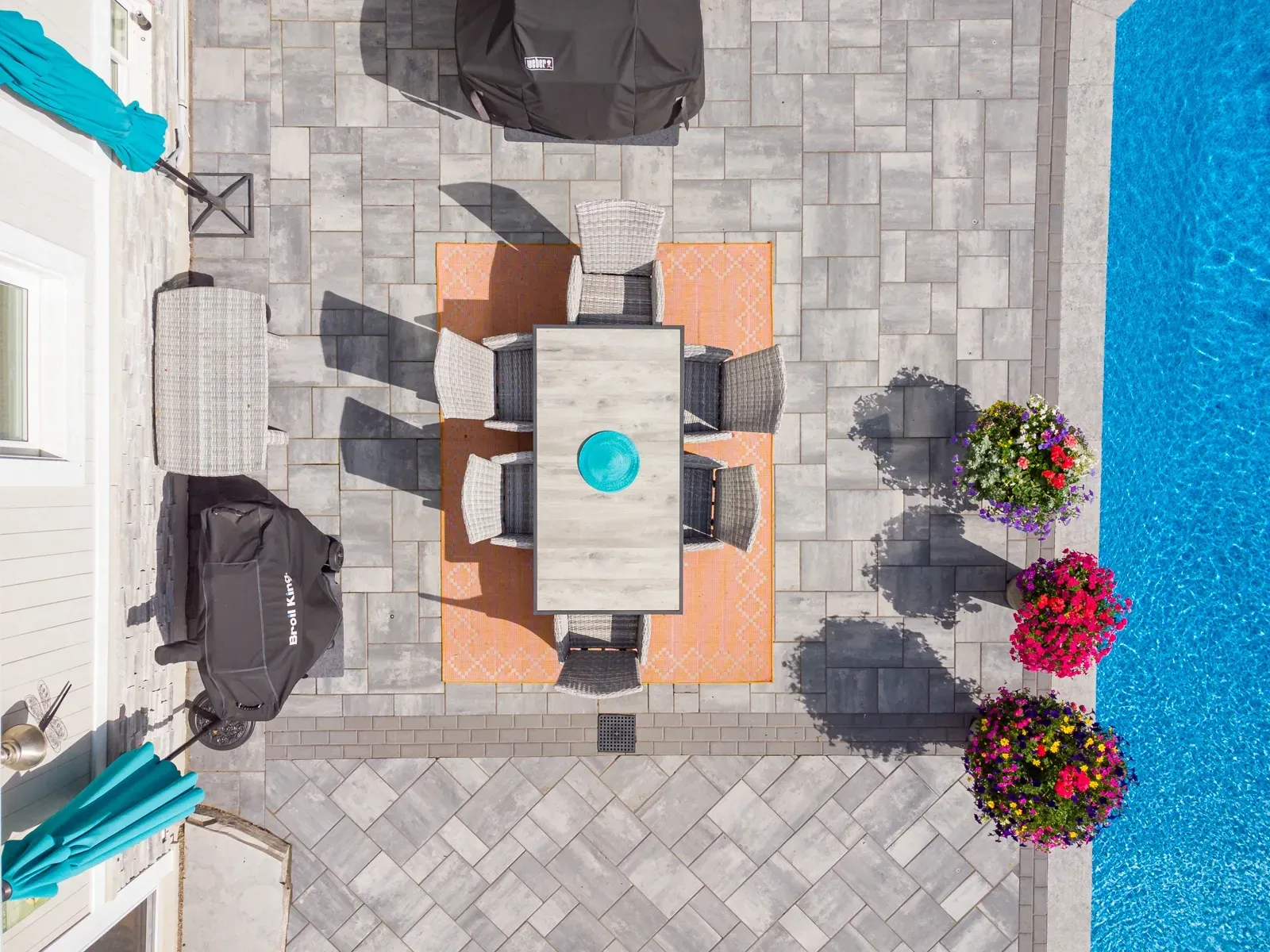 An aerial view of a patio with a table and chairs next to a pool.