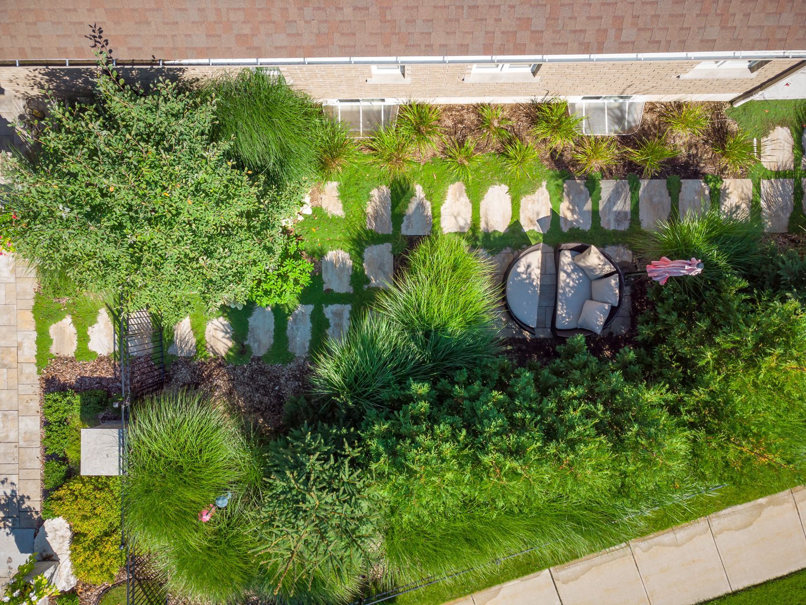 An aerial view of a lush green garden in front of a house.
