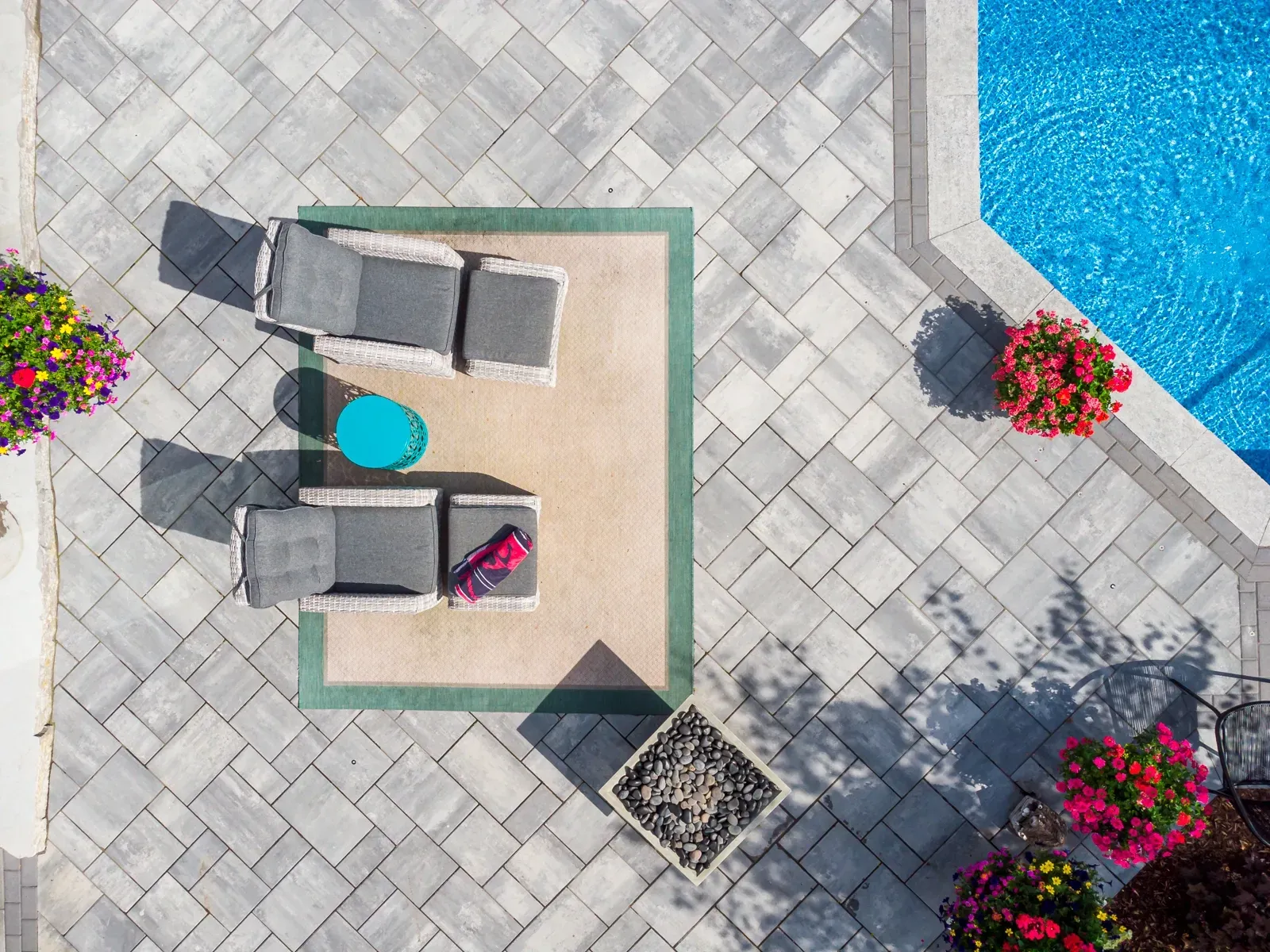 An aerial view of a patio with chairs and a table next to a pool.