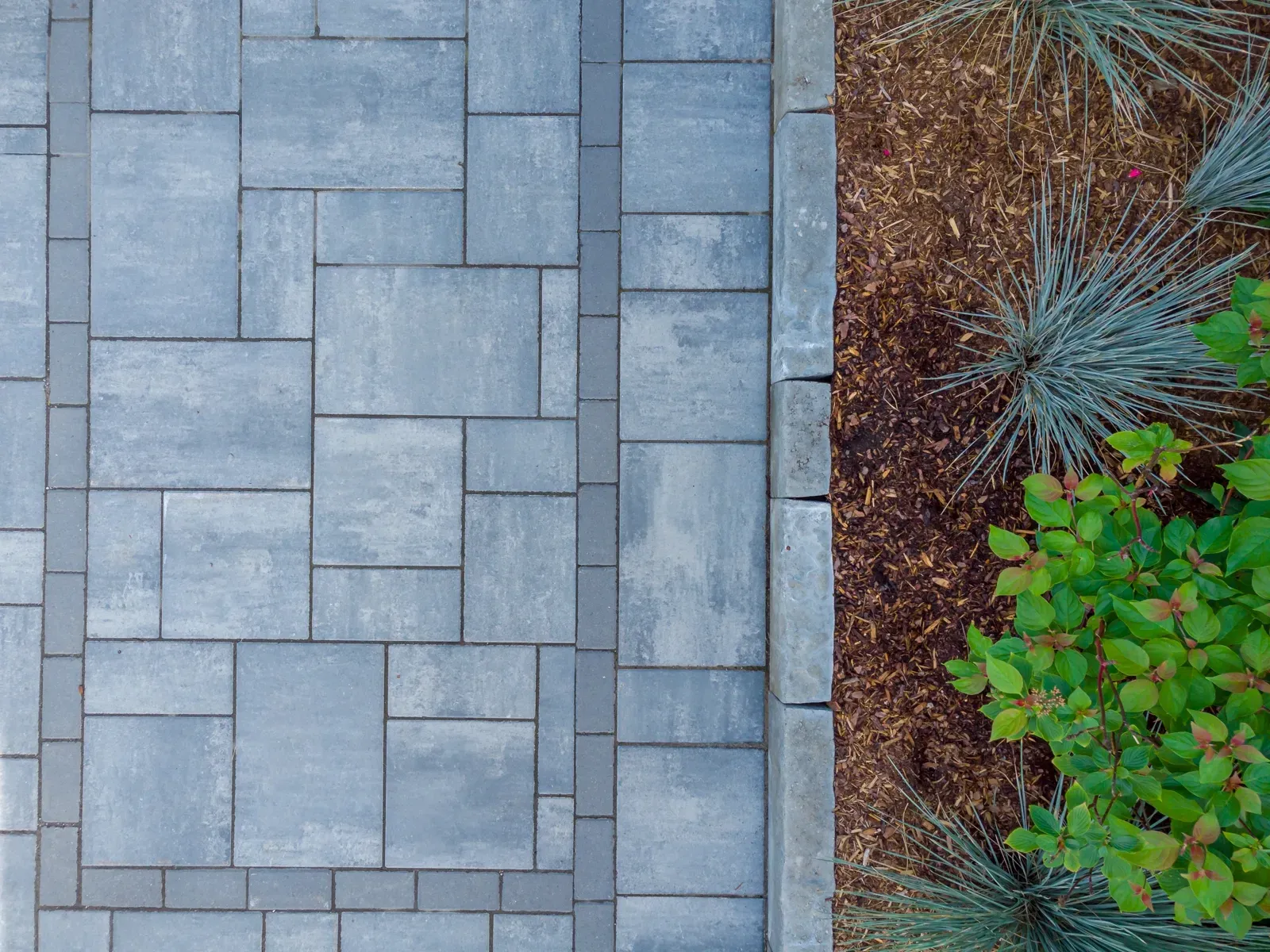 An aerial view of a patio with a bush in the background.