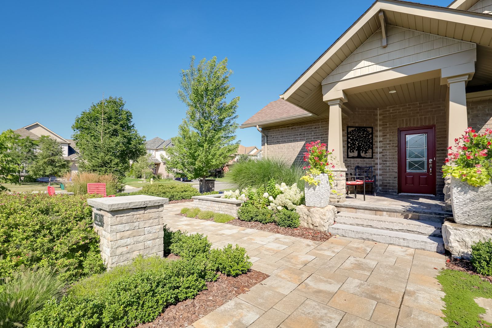 A house with a red door and a brick walkway leading to it.