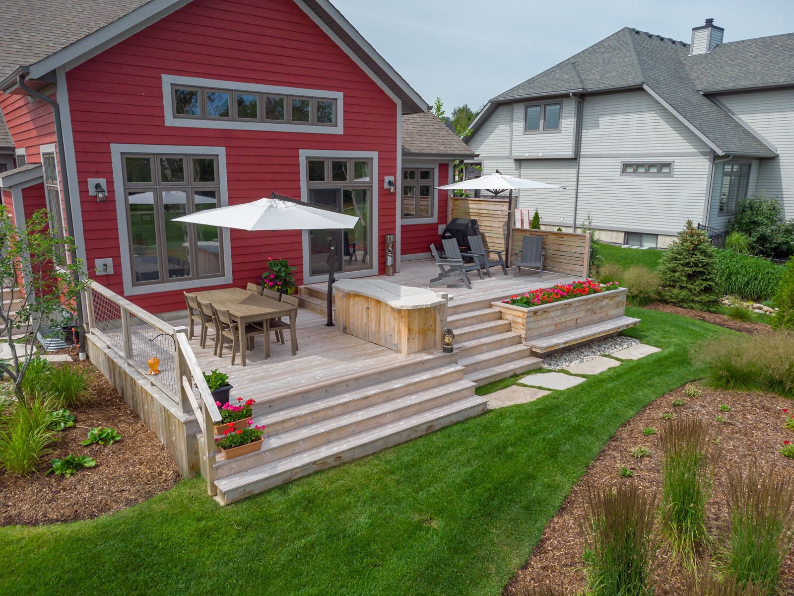 An aerial view of a backyard with a large deck and stairs leading up to it.