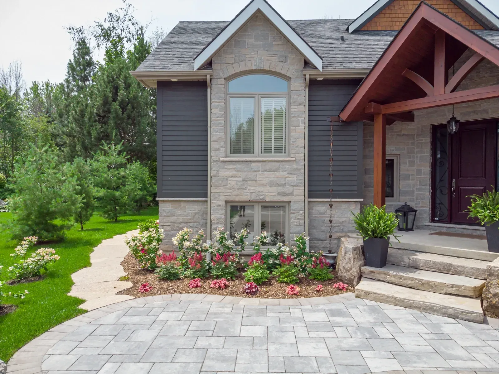 A large house with a brick driveway in front of it.