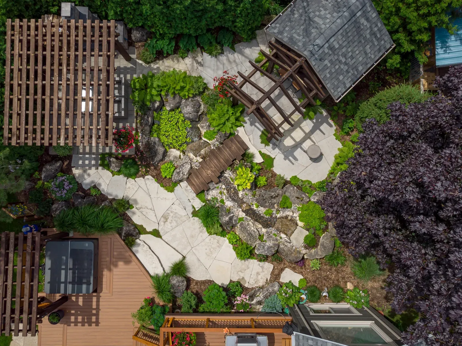 An aerial view of a garden with a house in the background.