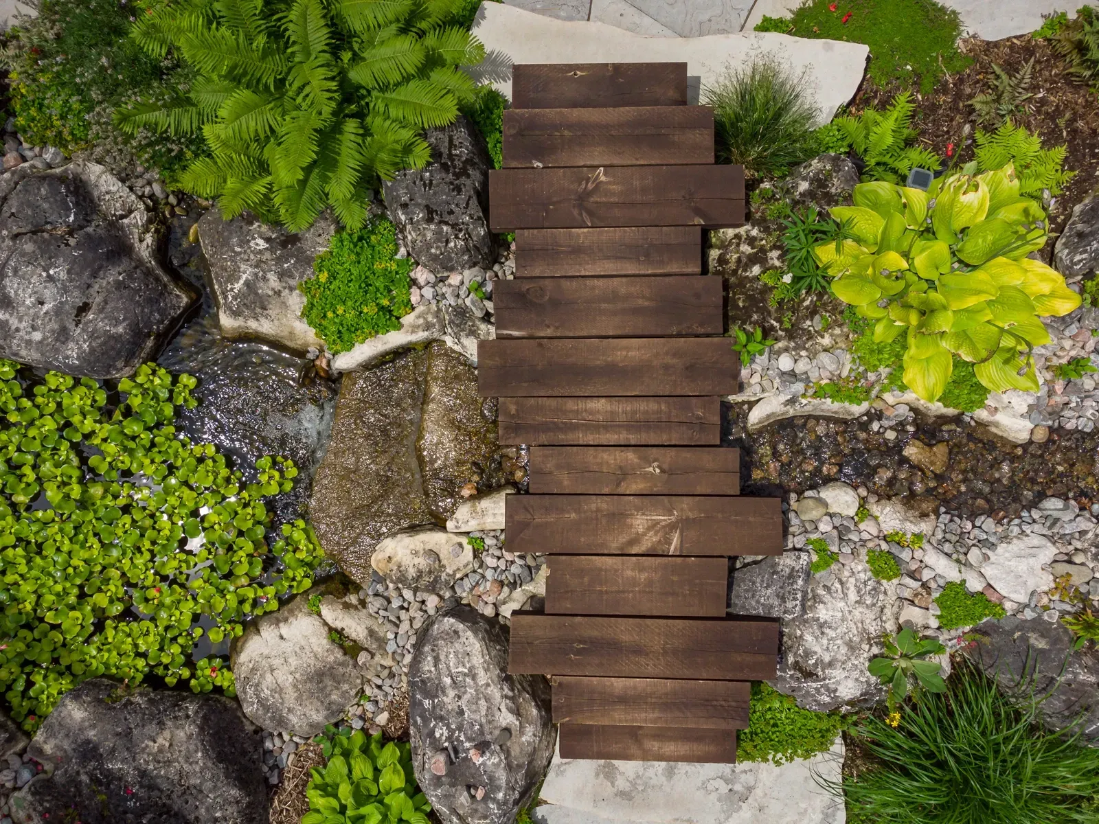 An aerial view of a wooden bridge in a rock garden.