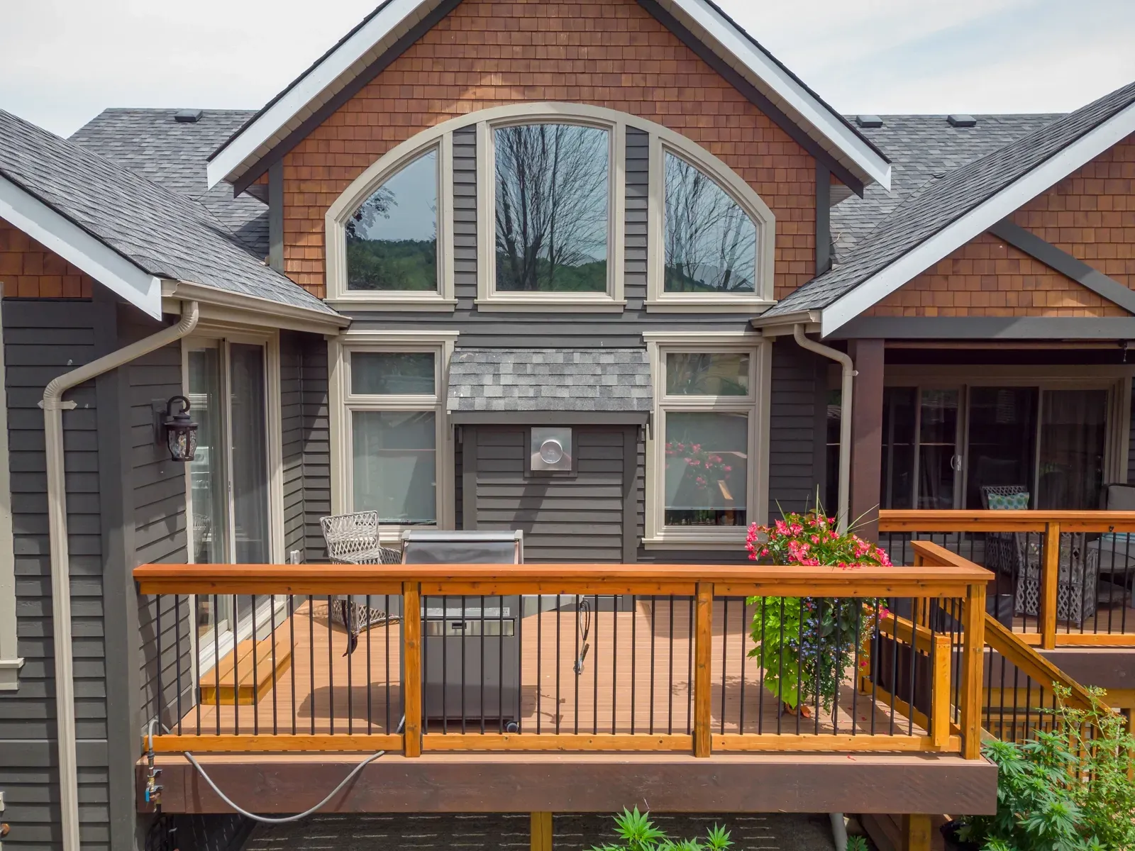 A large brick house with a wooden deck in front of it.