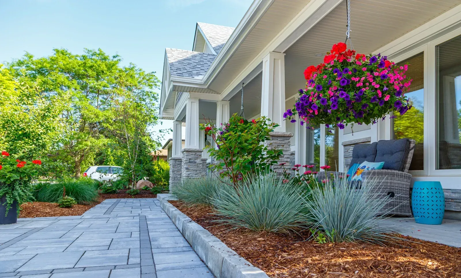 A house with a patio and flowers in front of it.
