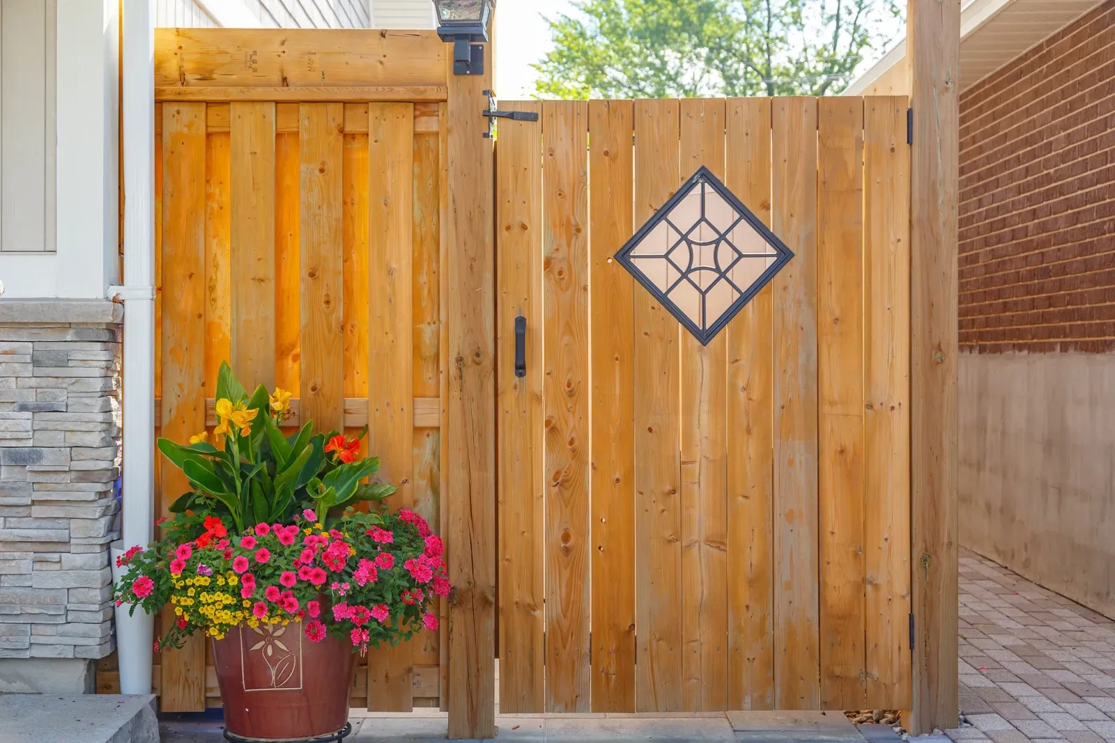 A wooden fence with a potted plant in front of it.