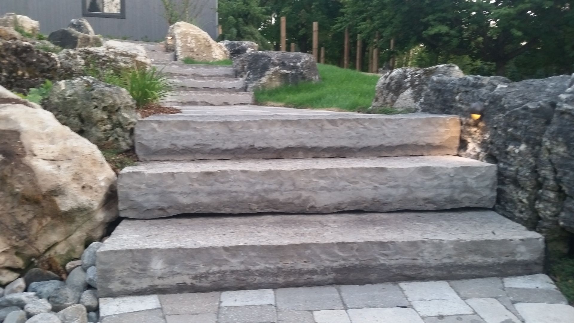 A set of stone stairs leading up to a house surrounded by rocks.