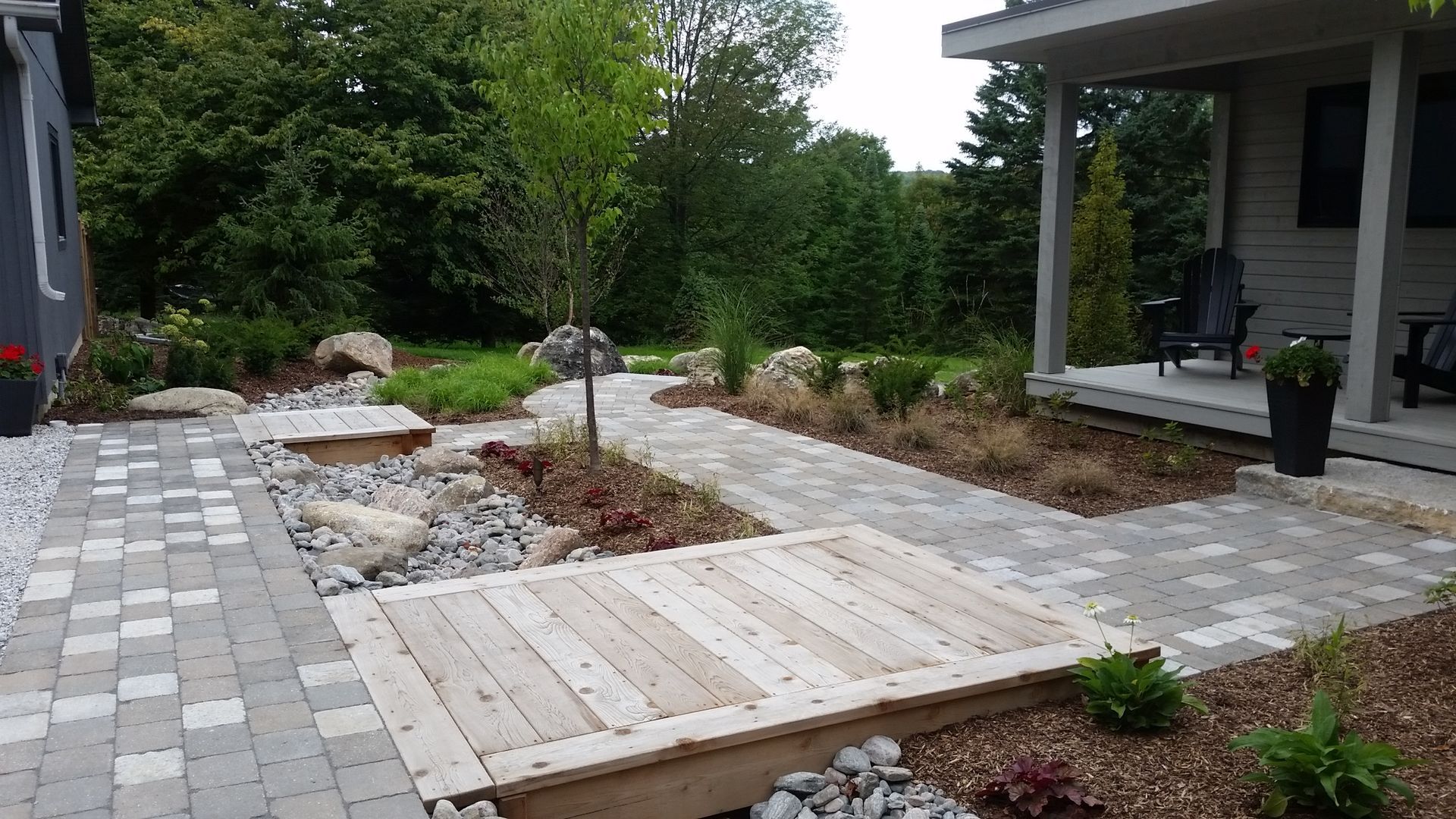 A wooden walkway leading to a house with a porch.