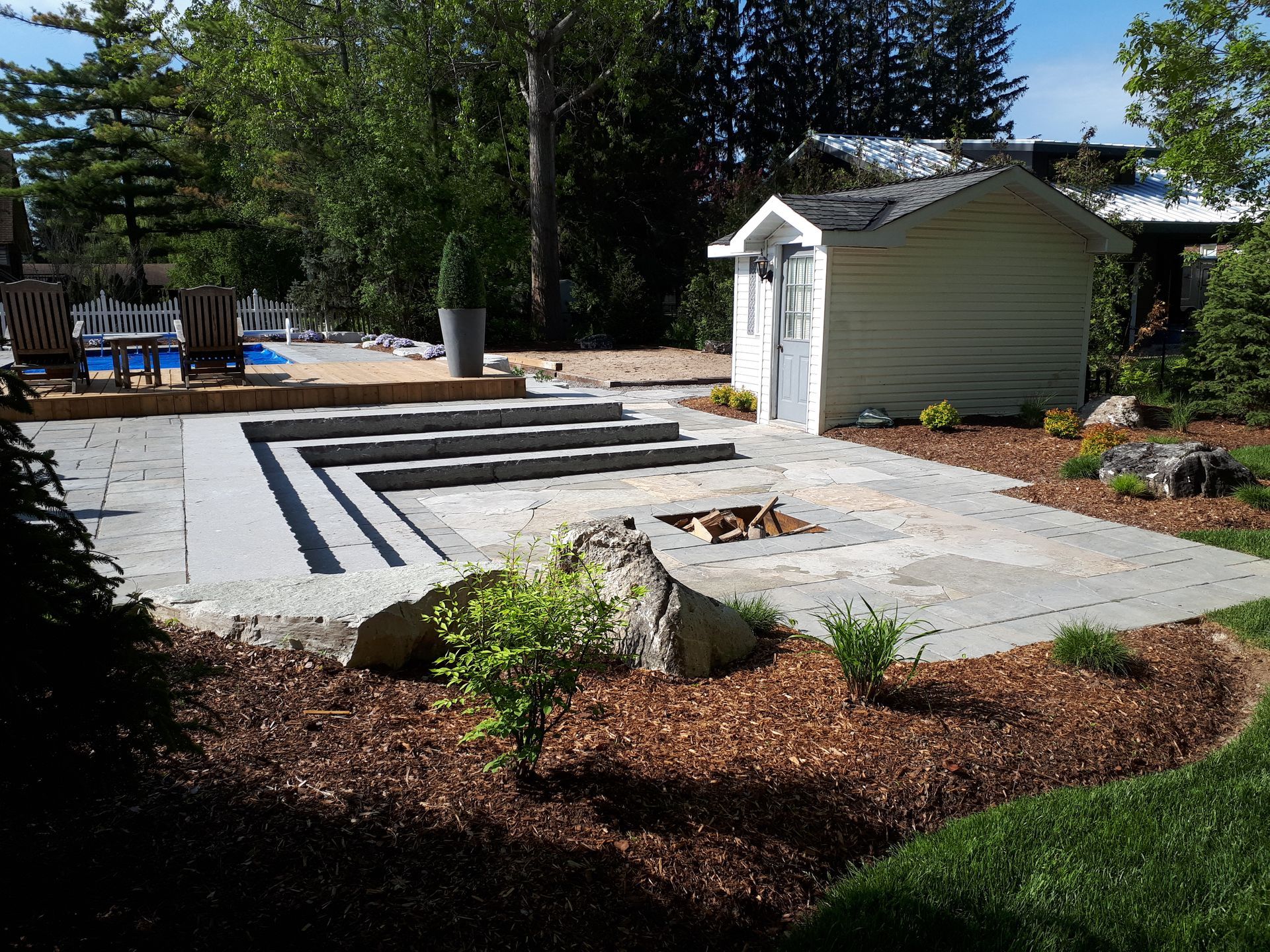 A backyard with a shed and a fire pit