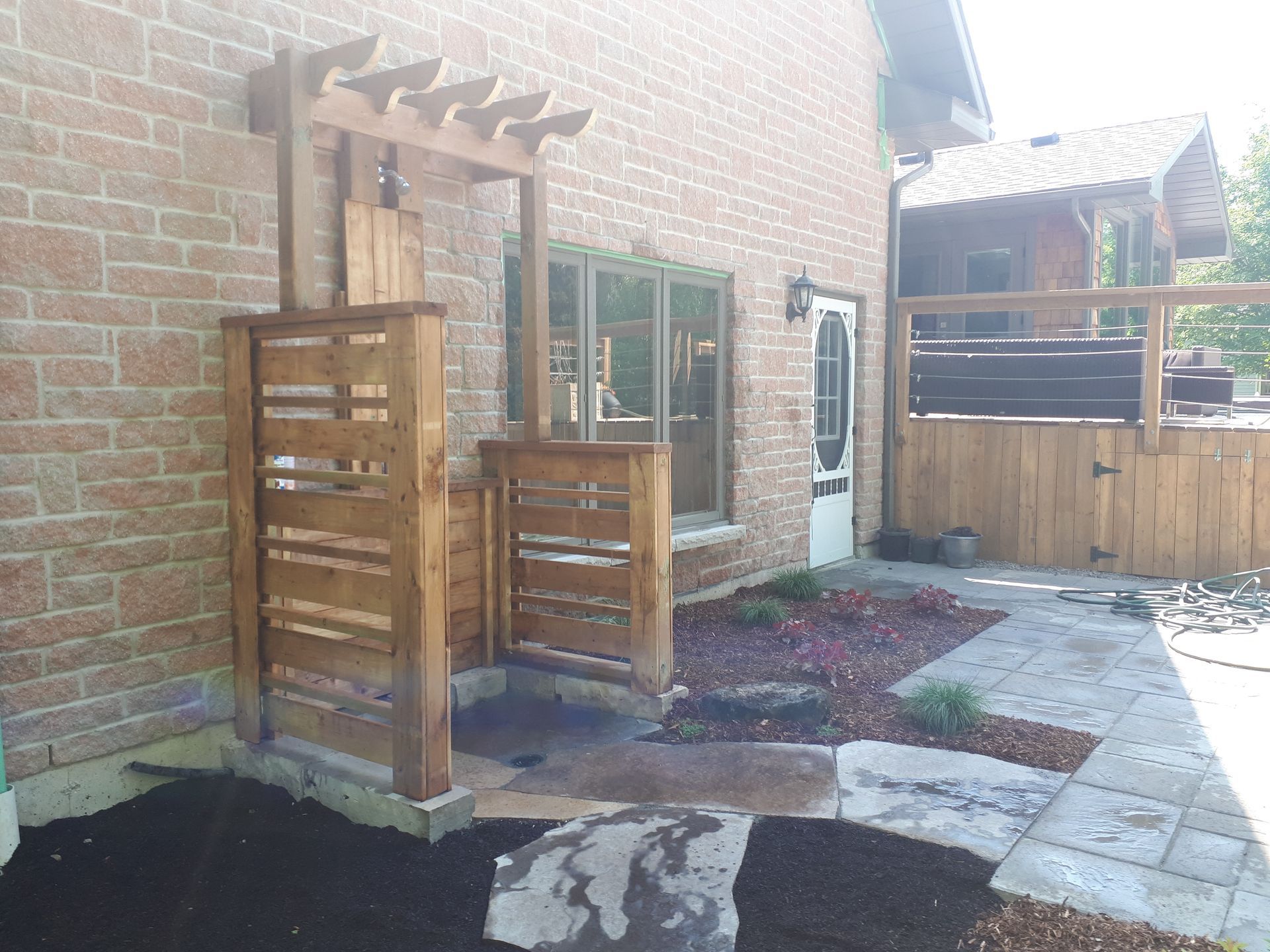 A brick house with a wooden pergola on the side of it