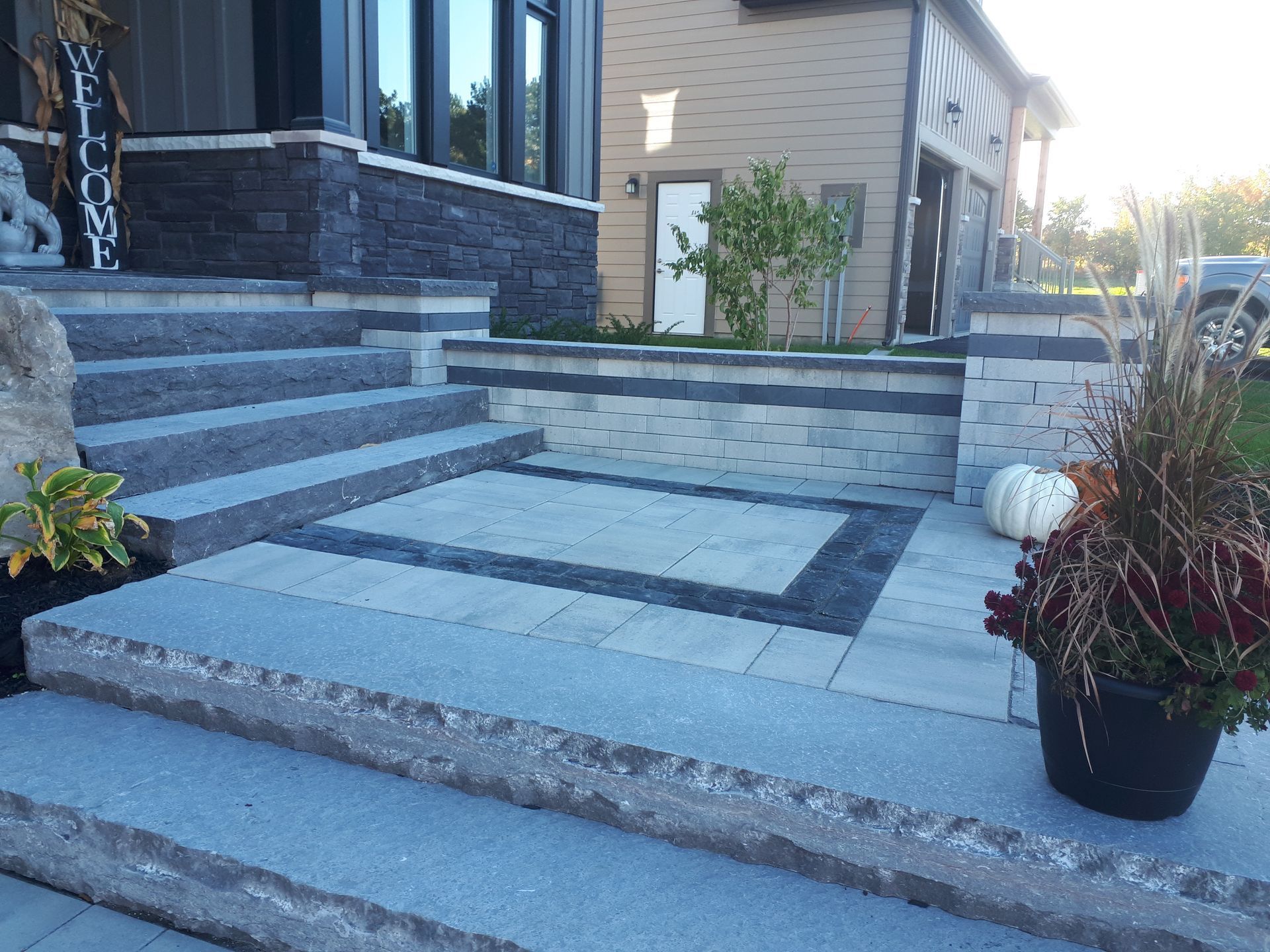 A staircase leading up to a house with a potted plant in front of it.
