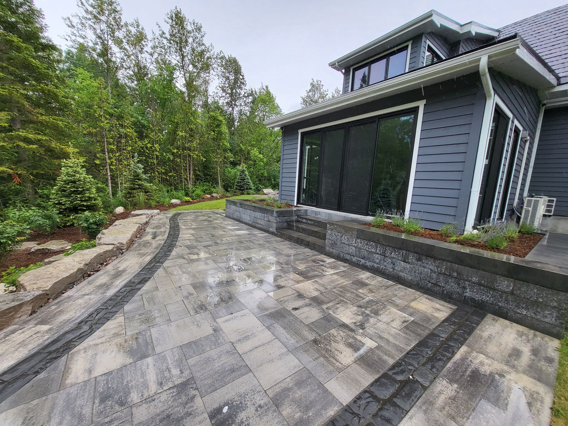 A large house with a patio in front of it surrounded by trees.