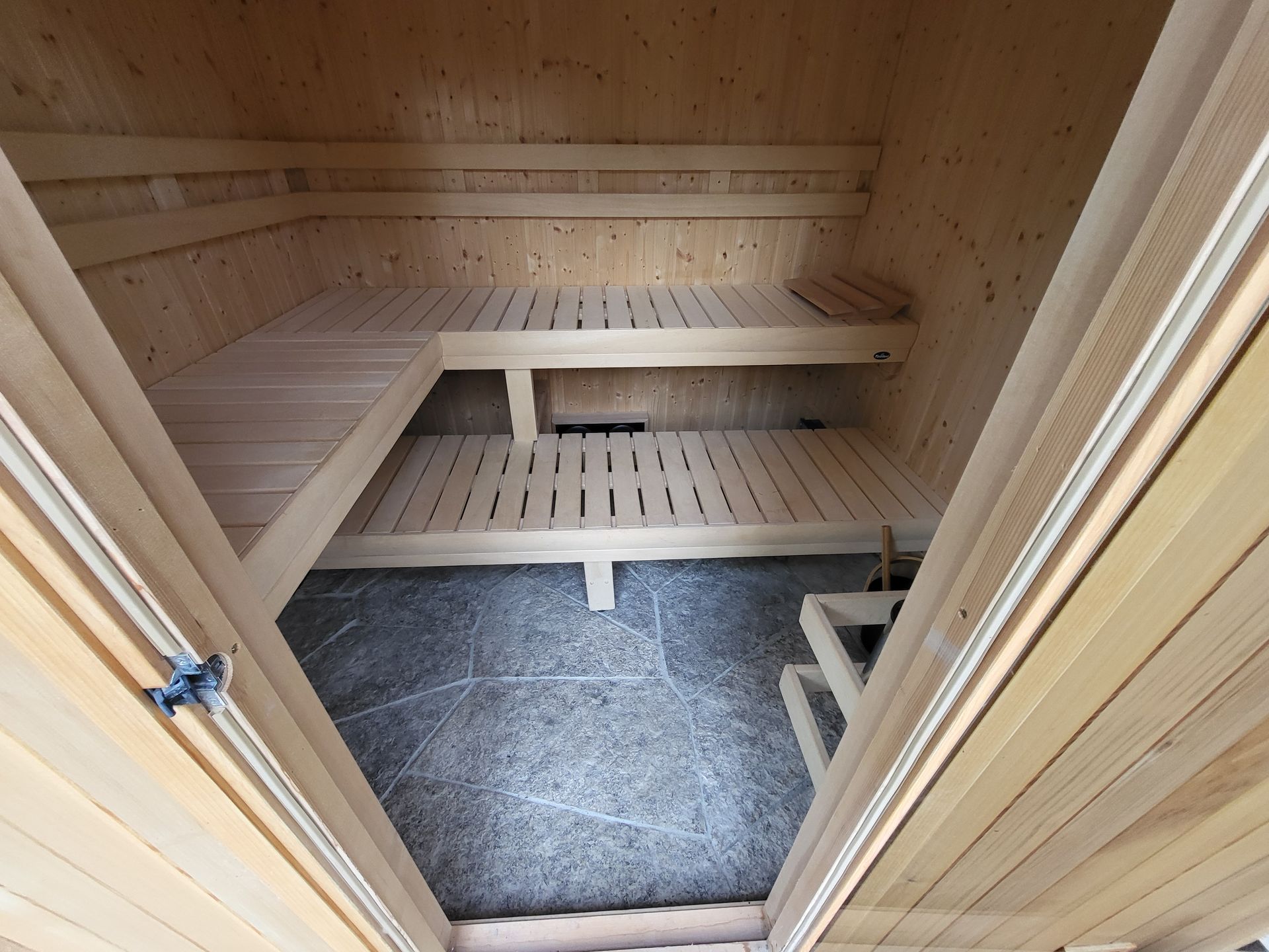 The inside of a wooden sauna with the doors open