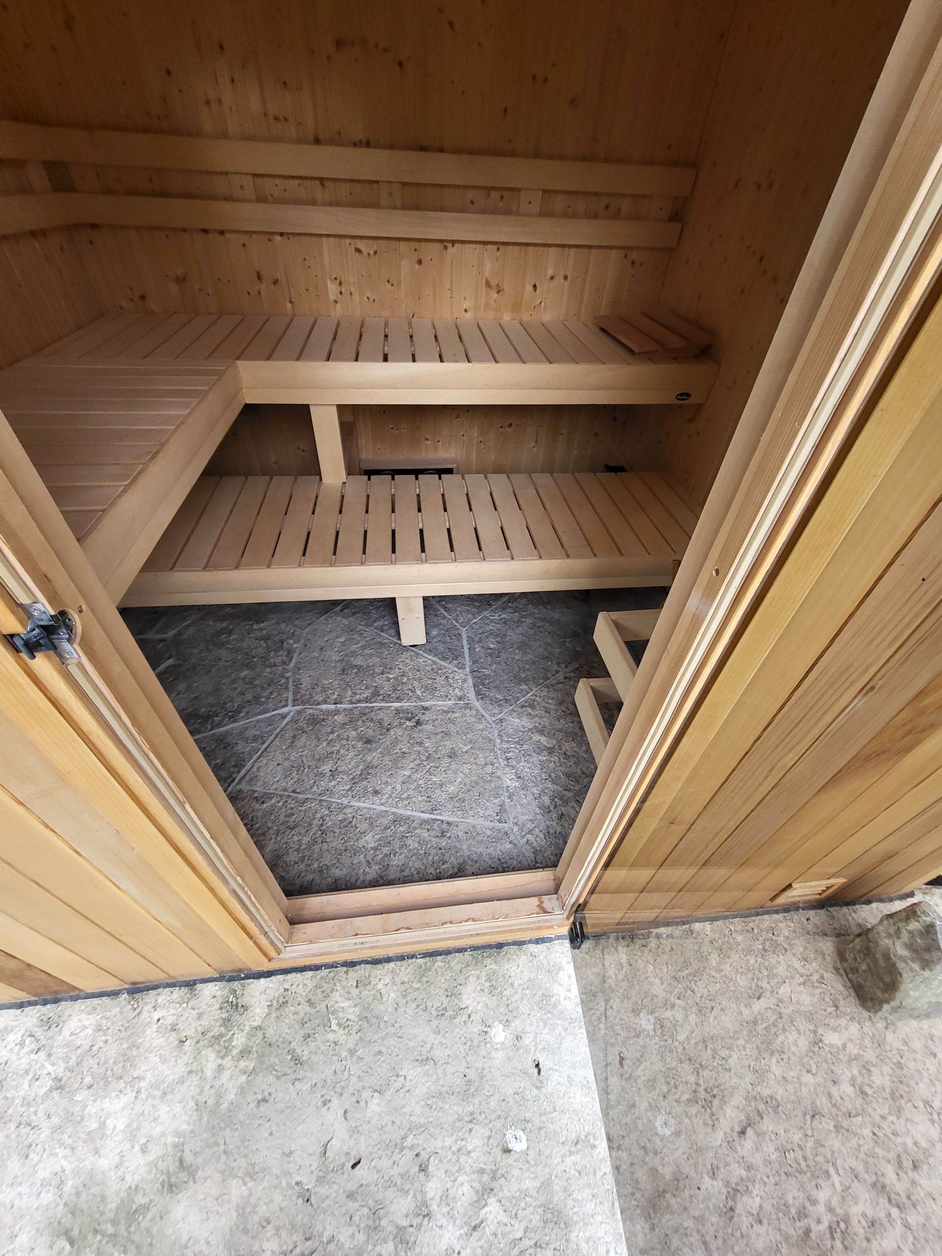 The inside of a wooden sauna with the door open