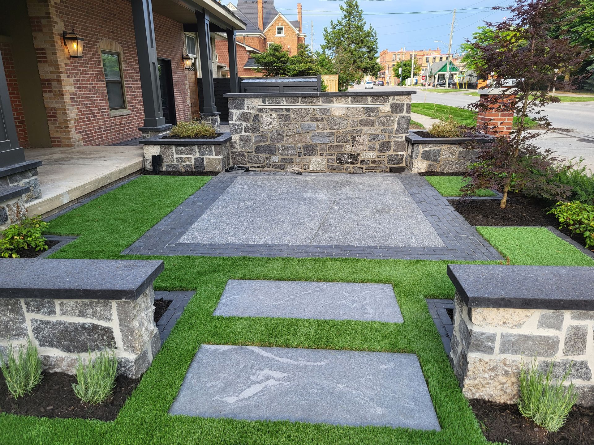 A brick house with a lush green lawn in front of it.