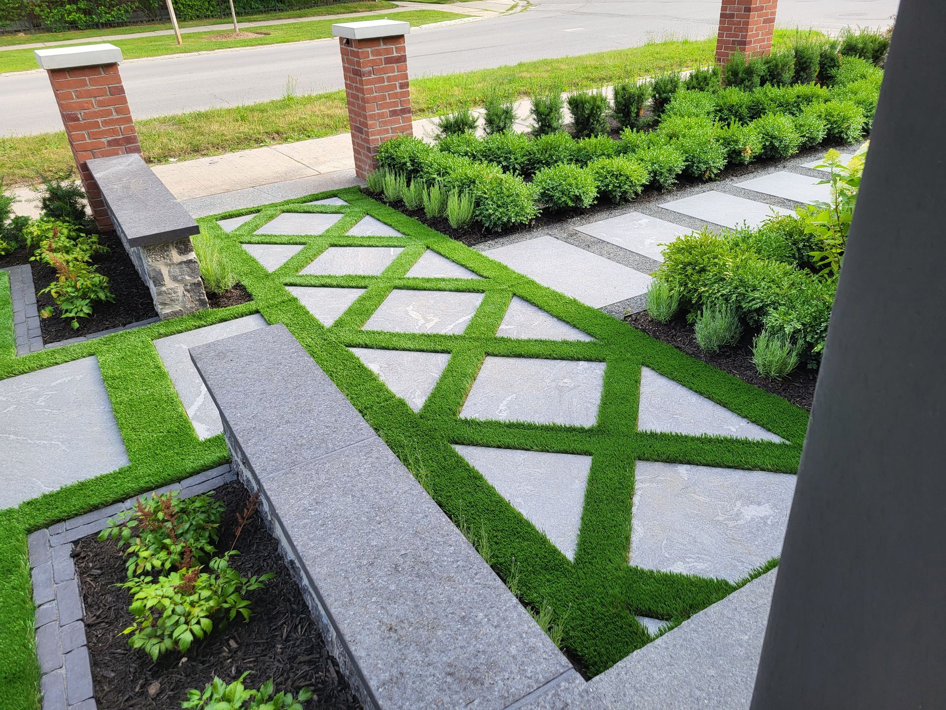 A lush green garden with a walkway and a bench.