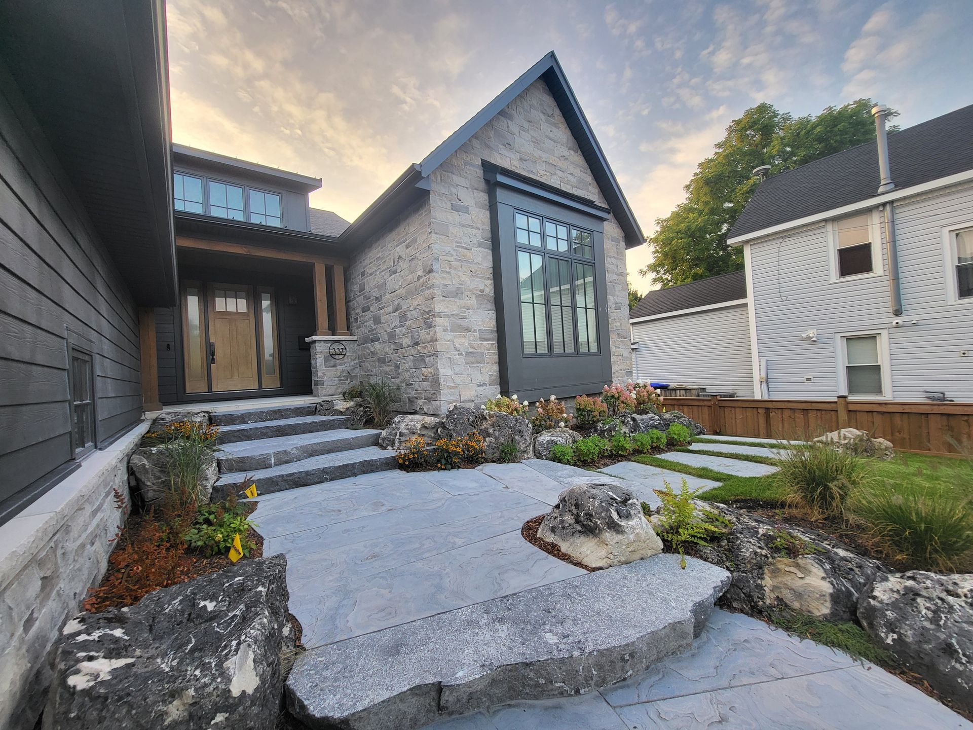The front of a house with stairs leading up to it and a large window.