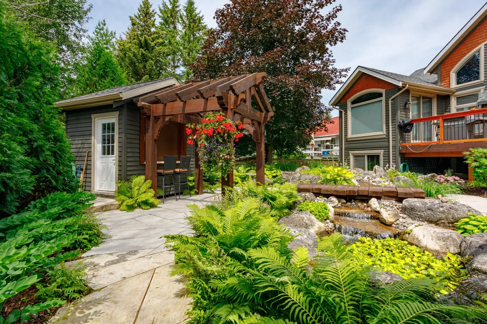 A house with a pergola and a patio in front of it.