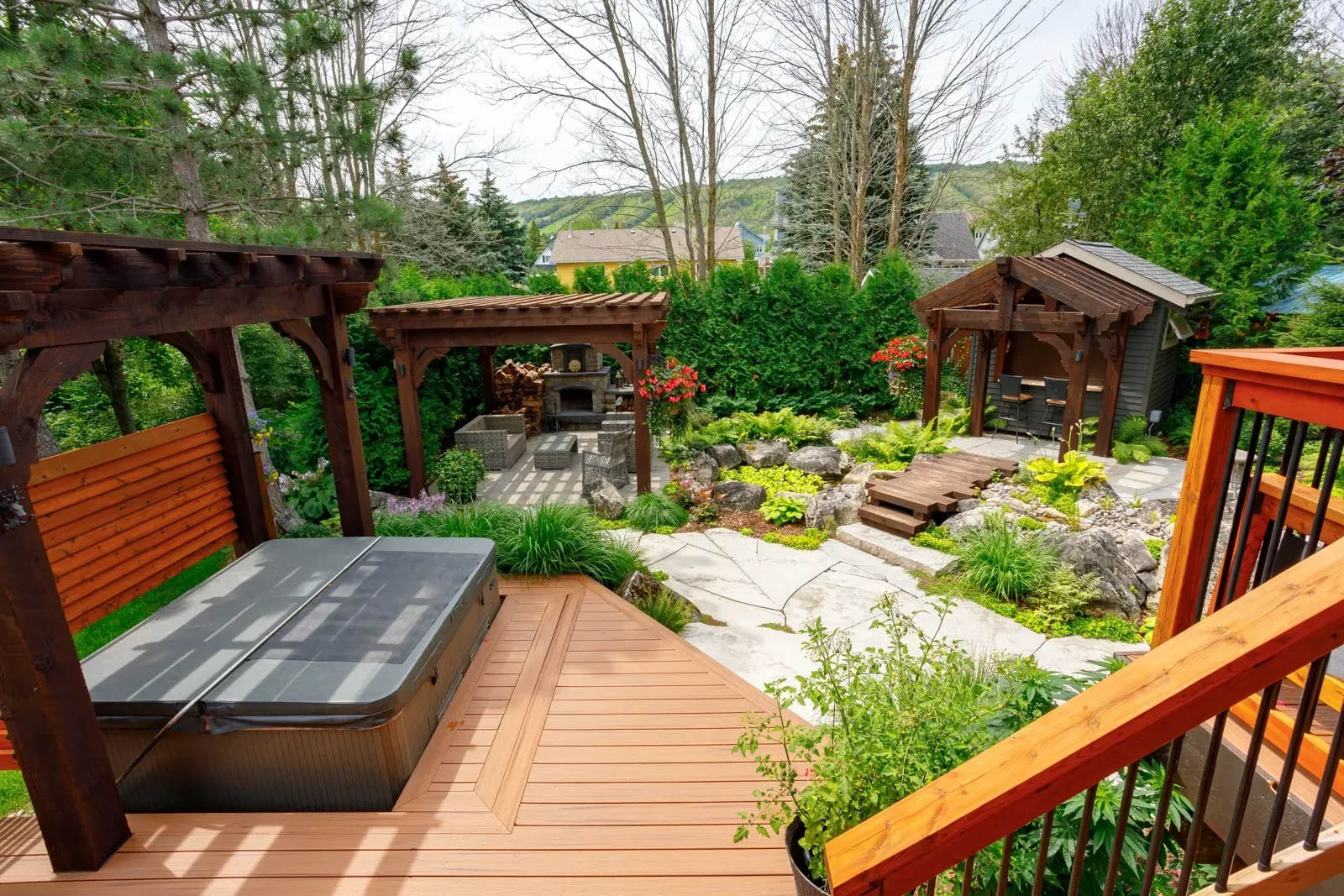 A wooden deck with a hot tub and a pergola in the backyard.