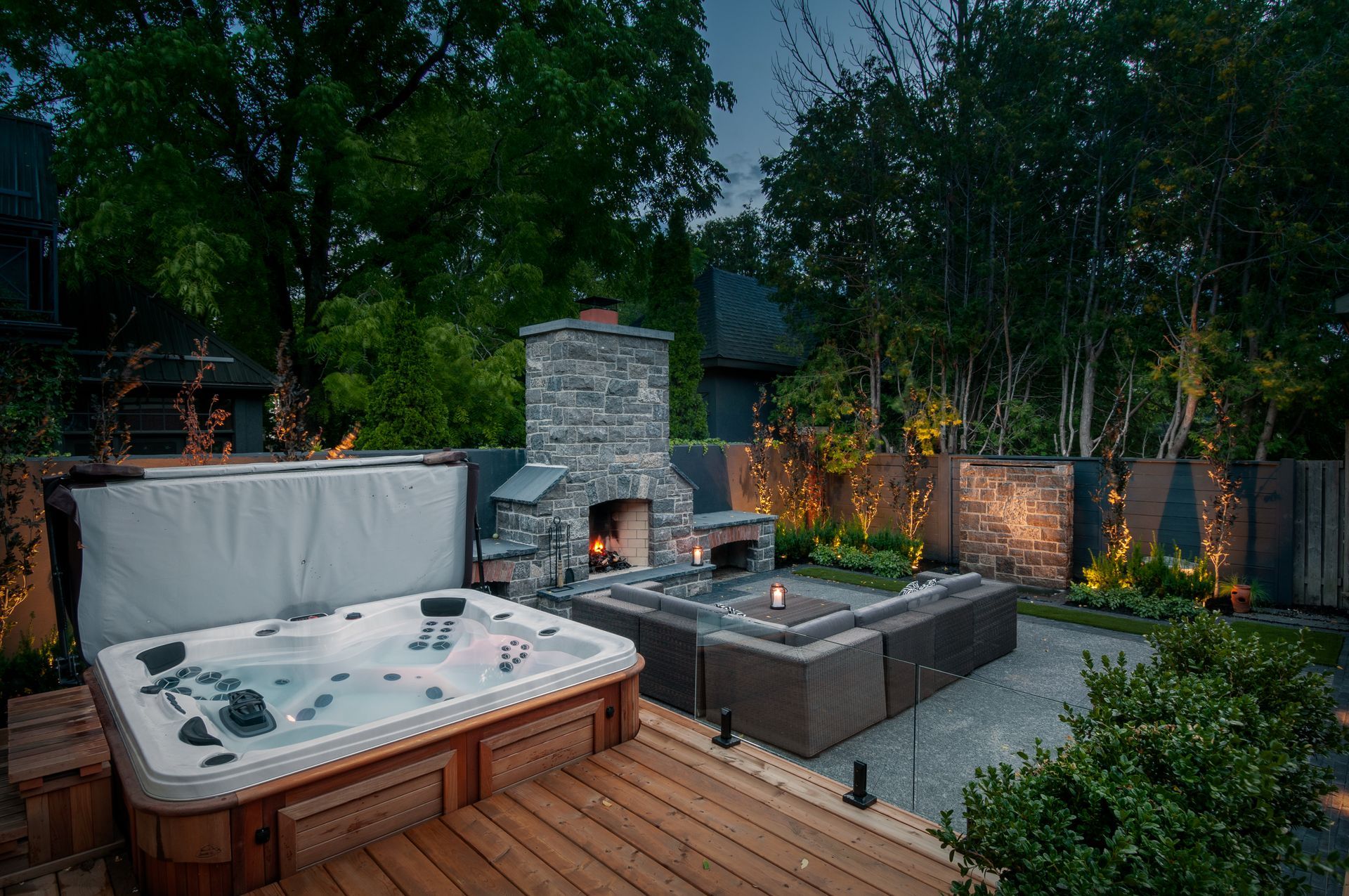 A hot tub is sitting on a wooden deck next to a fireplace.
