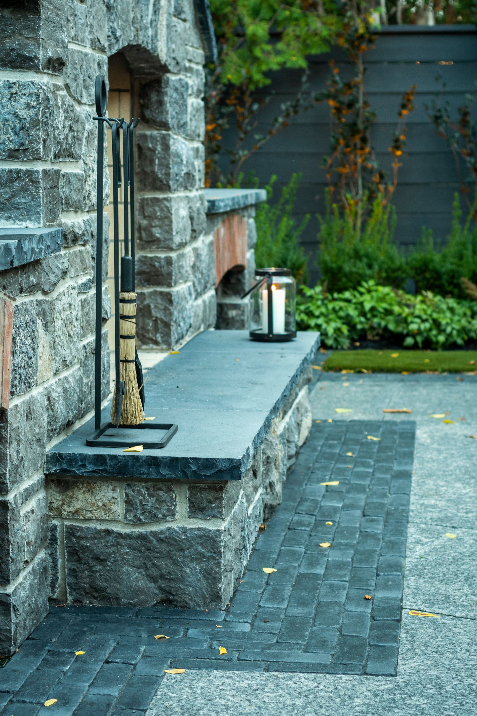 A stone bench with a candle on it next to a fireplace.