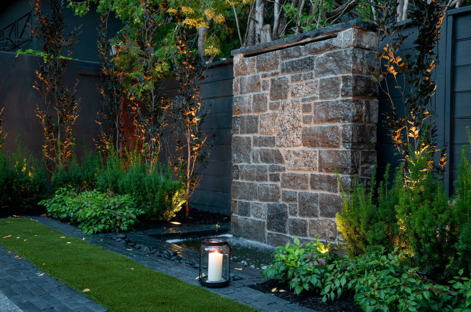 A brick wall with a lantern in front of it.