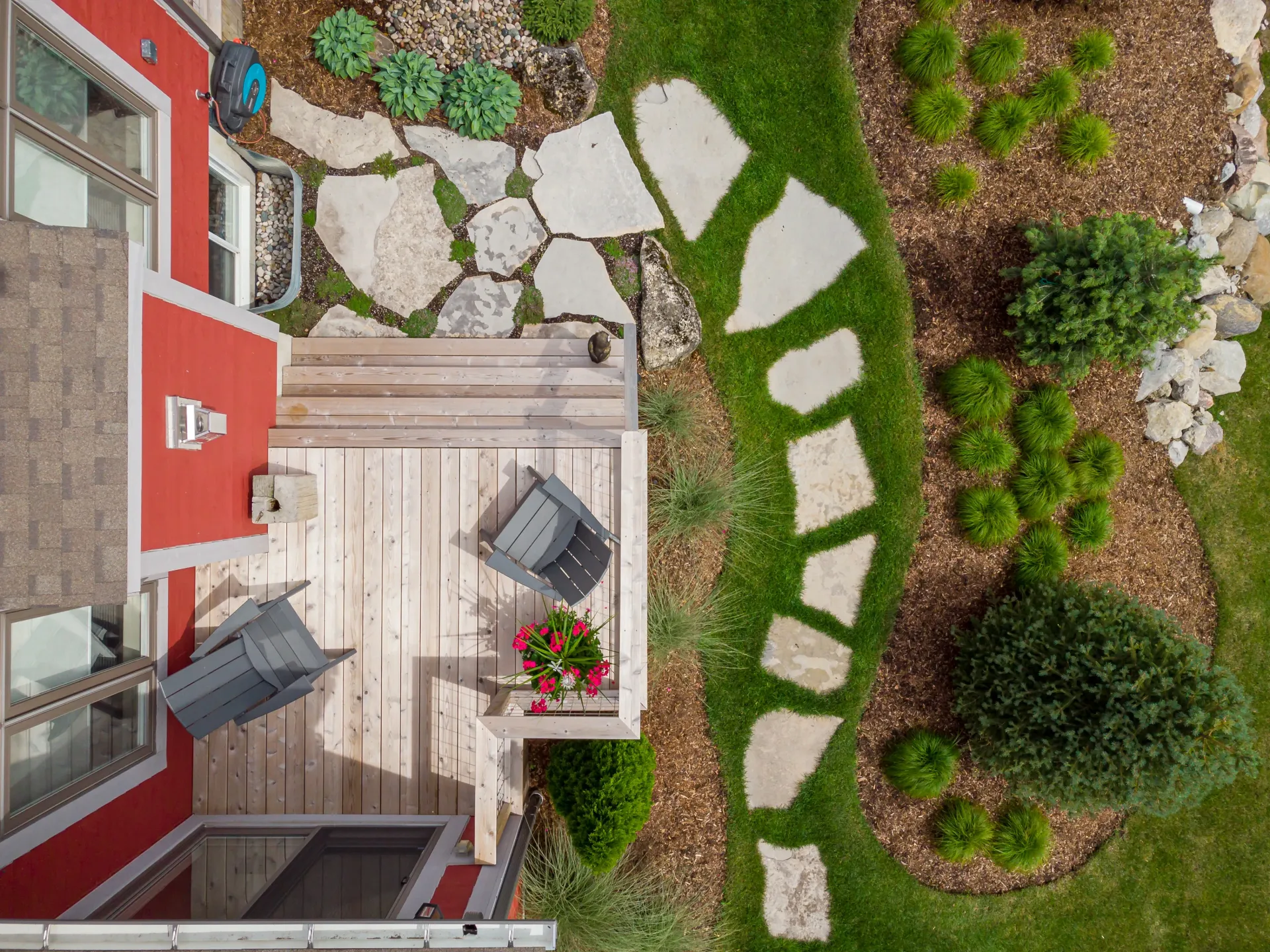 An aerial view of a backyard with a wooden deck and chairs.