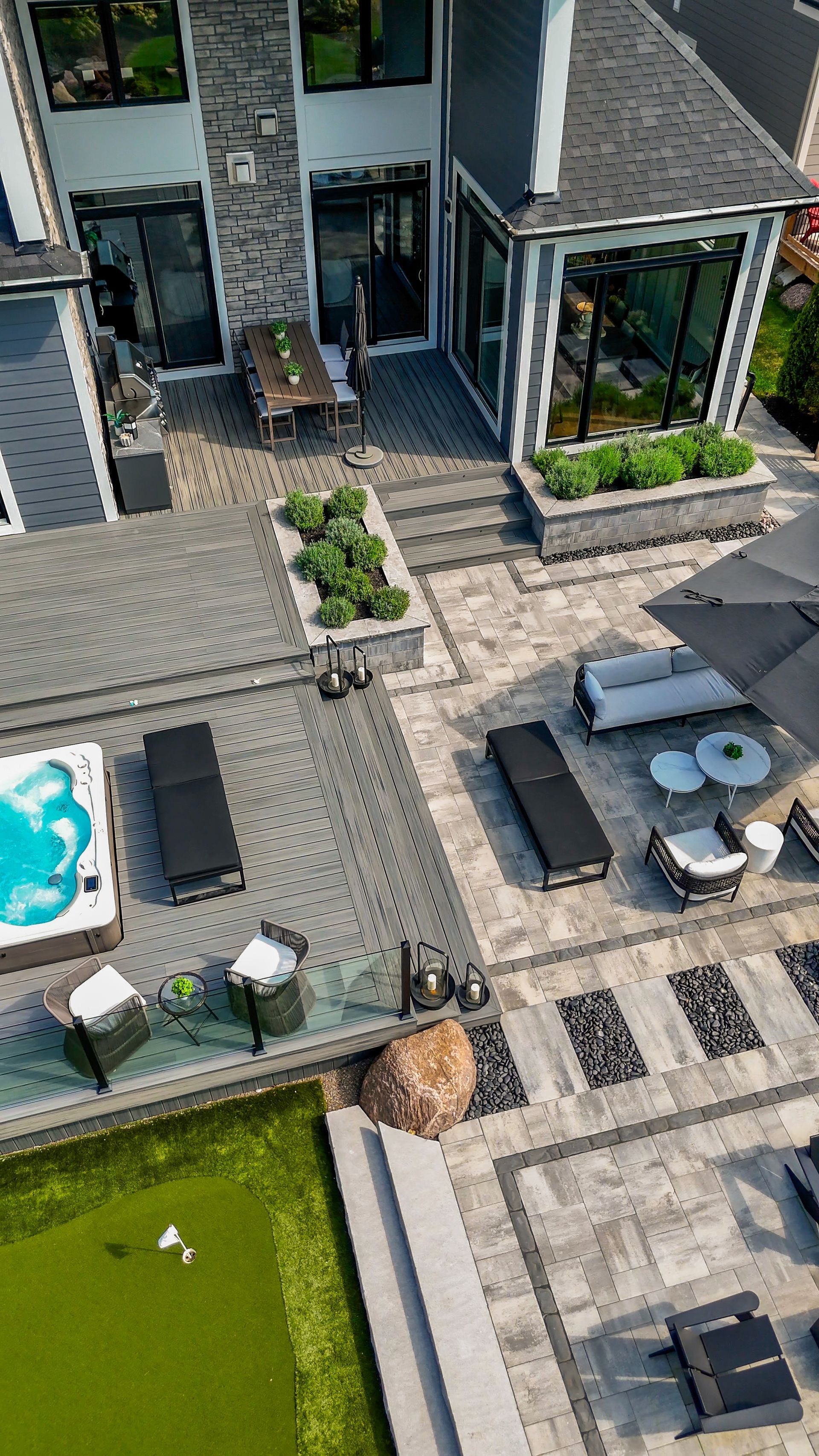 An aerial view of a large house with a swimming pool and patio furniture.